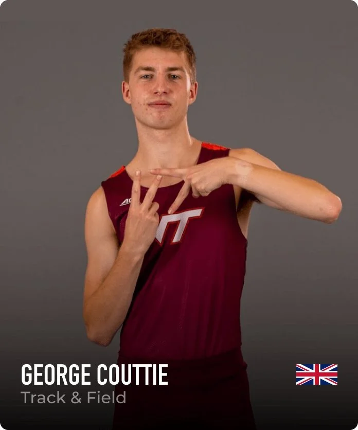 Young man in maroon athletic jersey with white and red lettering, posing with fingers making a peace sign against a gray background.
