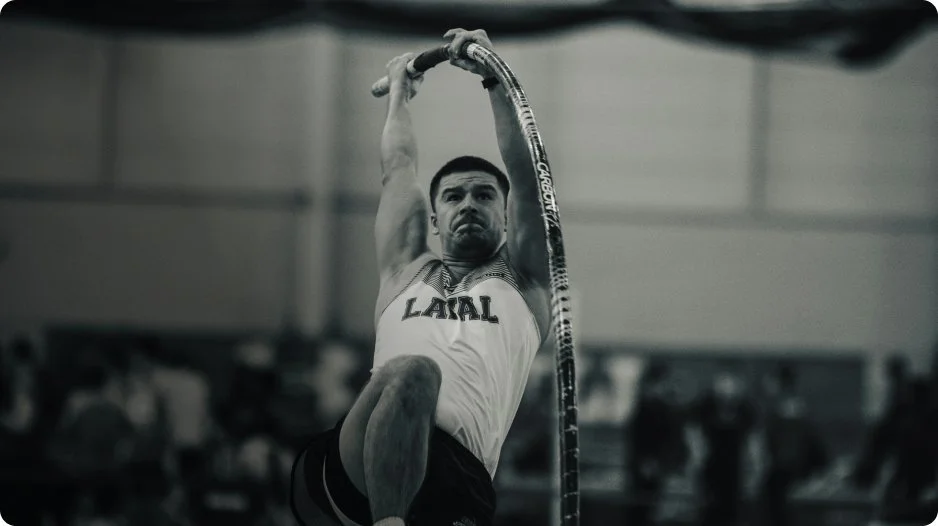 Male athlete performing an indoor pole vault.