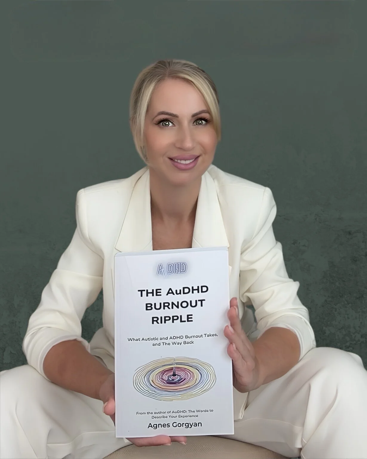 Author Agnes Gorgyan holding her book The AuDHD Burnout Ripple.
