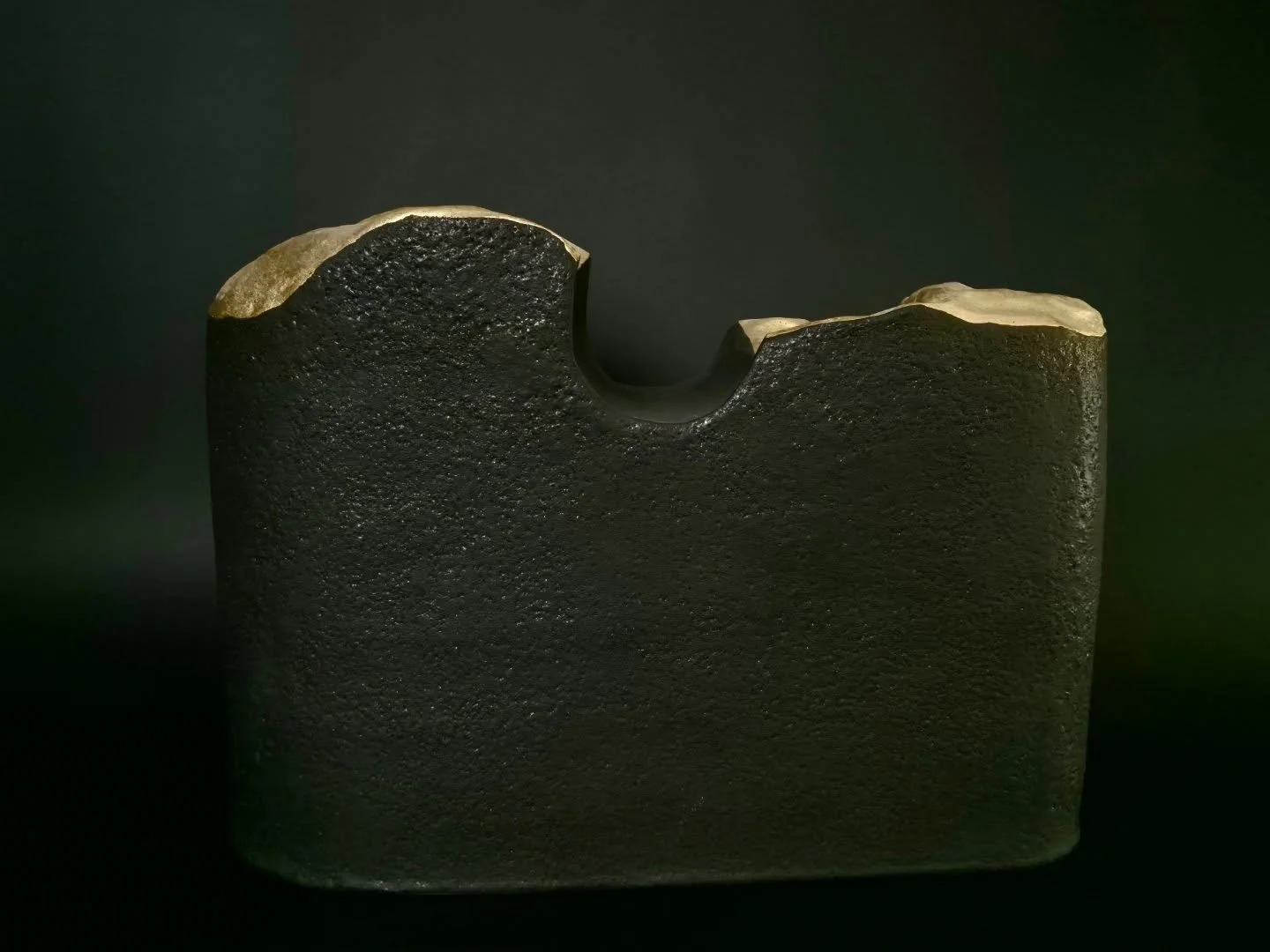 Comme un grand monolithe qui aurait &eacute;t&eacute; retrouv&eacute; cass&eacute; et dont l'int&eacute;rieur dor&eacute; nous dirait que la valeur est &agrave; l'int&eacute;rieur de la pierre...
Gr&egrave;s, &eacute;mai noir mat et or, 34*47*16 cm

