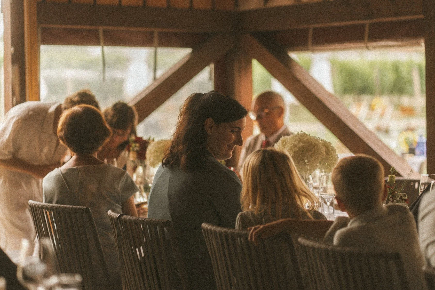 Guests seated and dining together along a long table during a wedding reception.