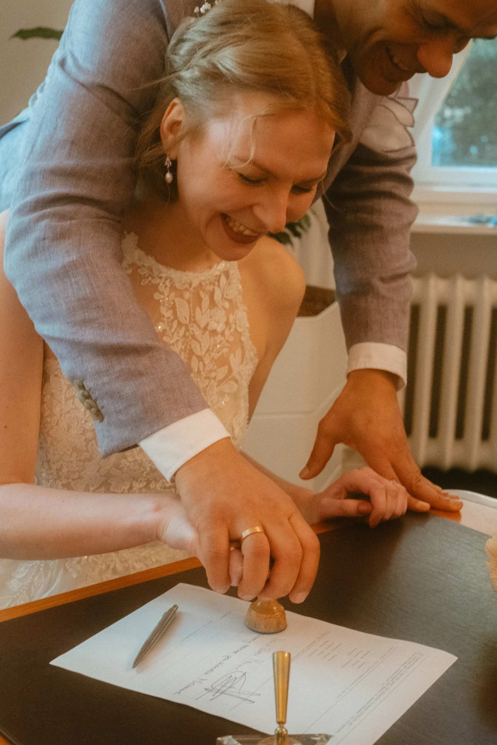 Couple laughing while signing official marriage certificate at Berlin Standesamt registry office