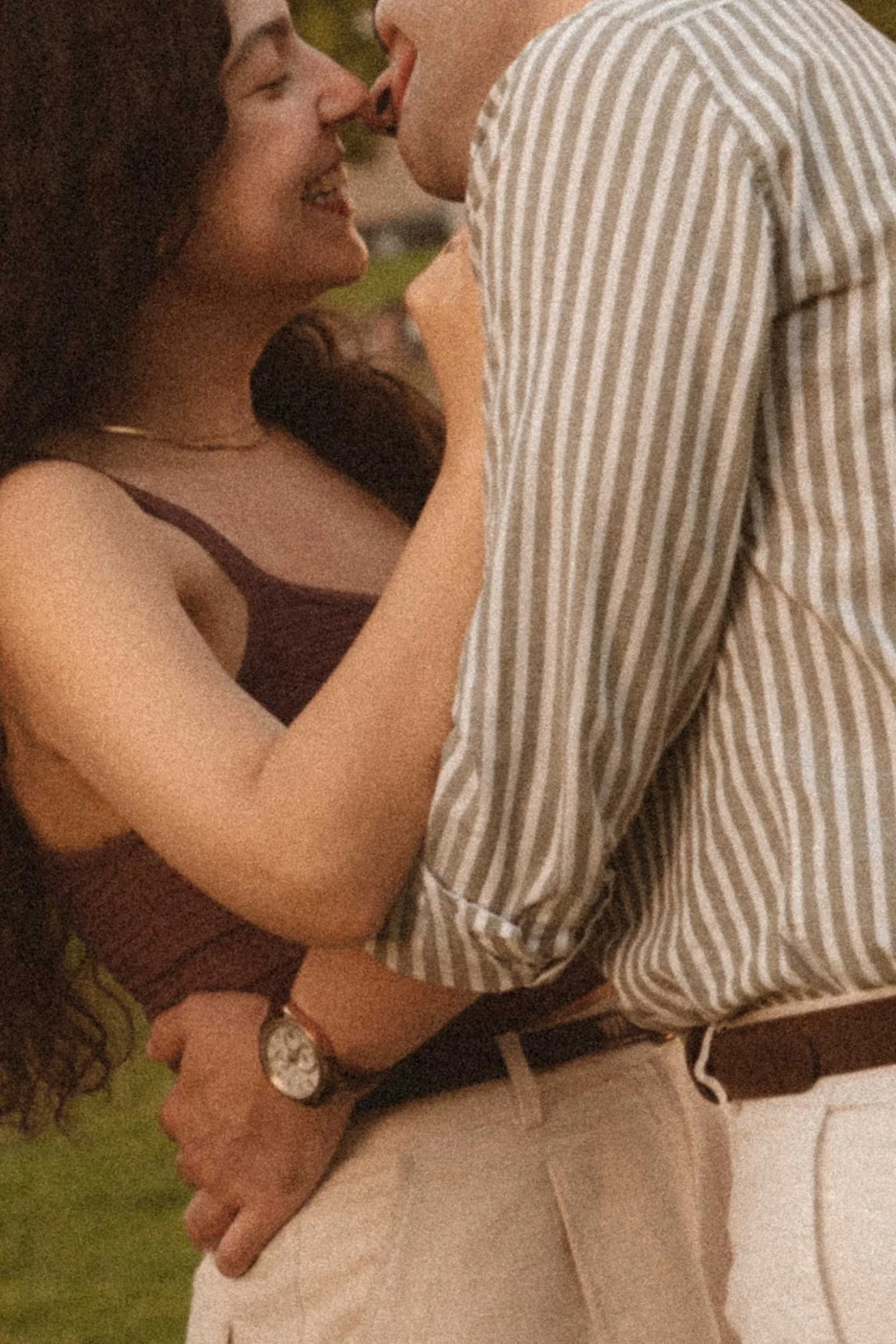 An intimate close-up of a couple sharing a joyful, tender embrace during an engagement photoshoot in Berlin at golden hour.