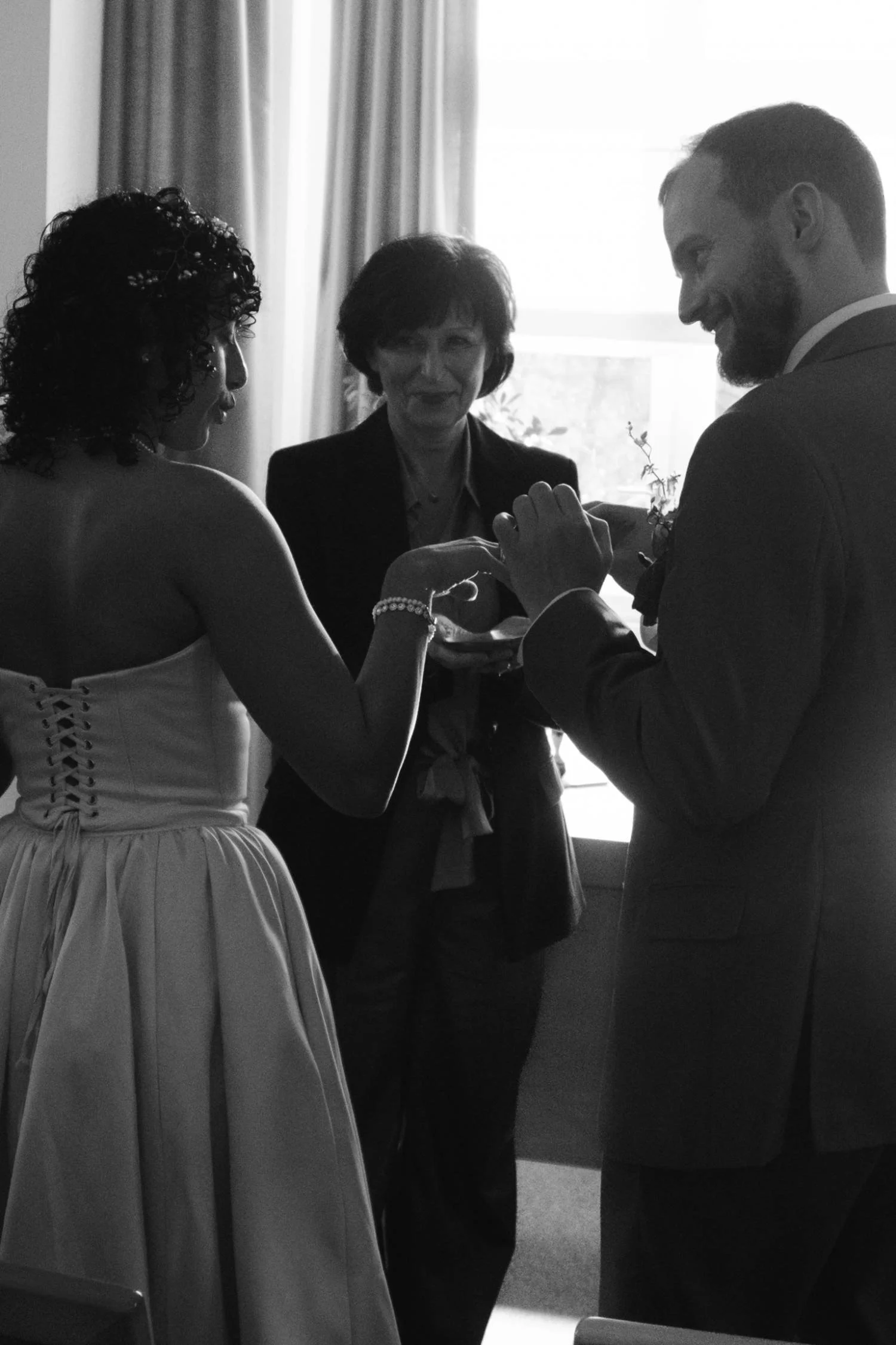 Black and white photograph of a couple exchanging rings during their civil wedding ceremony at the Berlin civil registry office.