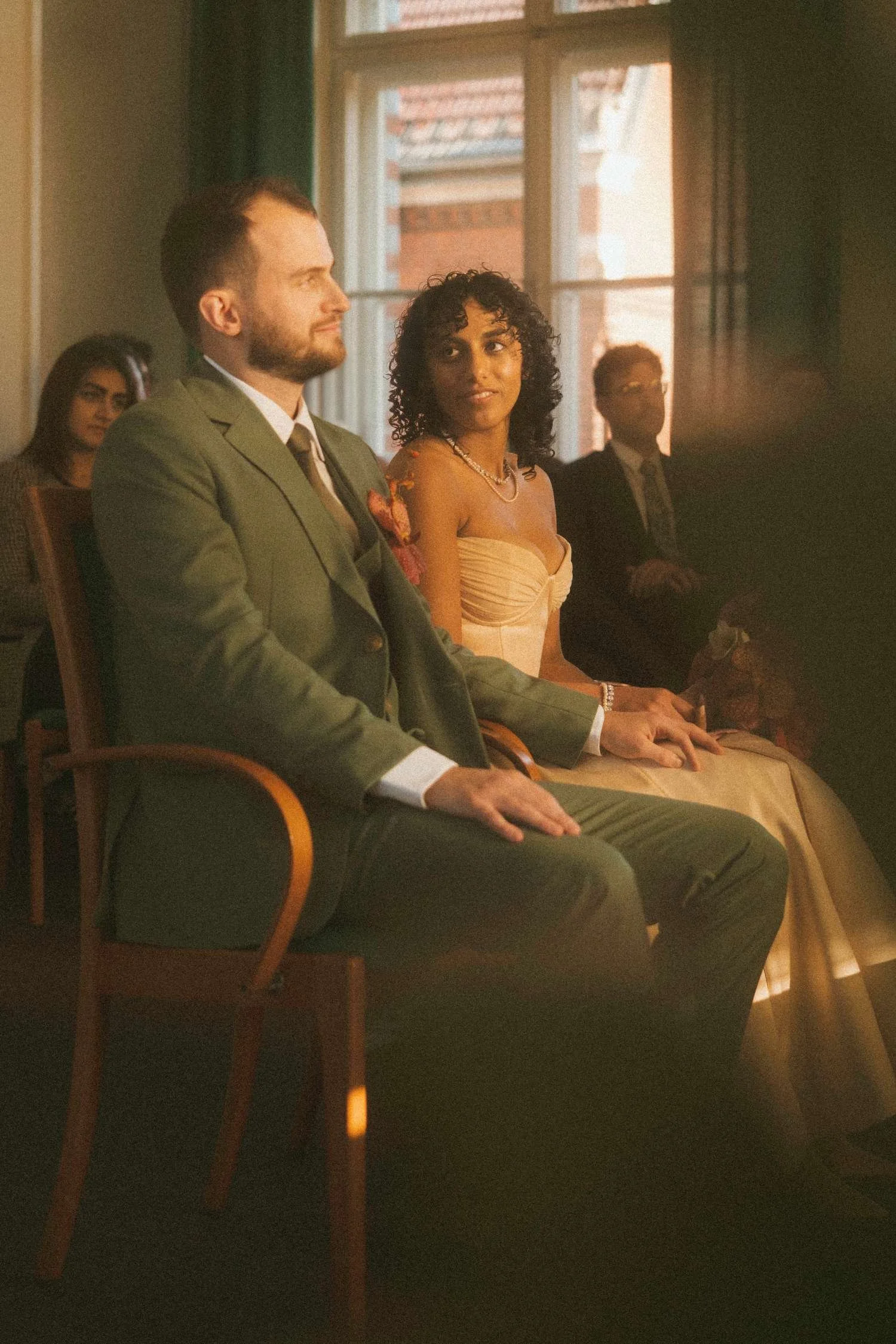 Bride and groom seated together during a civil wedding ceremony at the Standesamt in Berlin, sharing a quiet glance