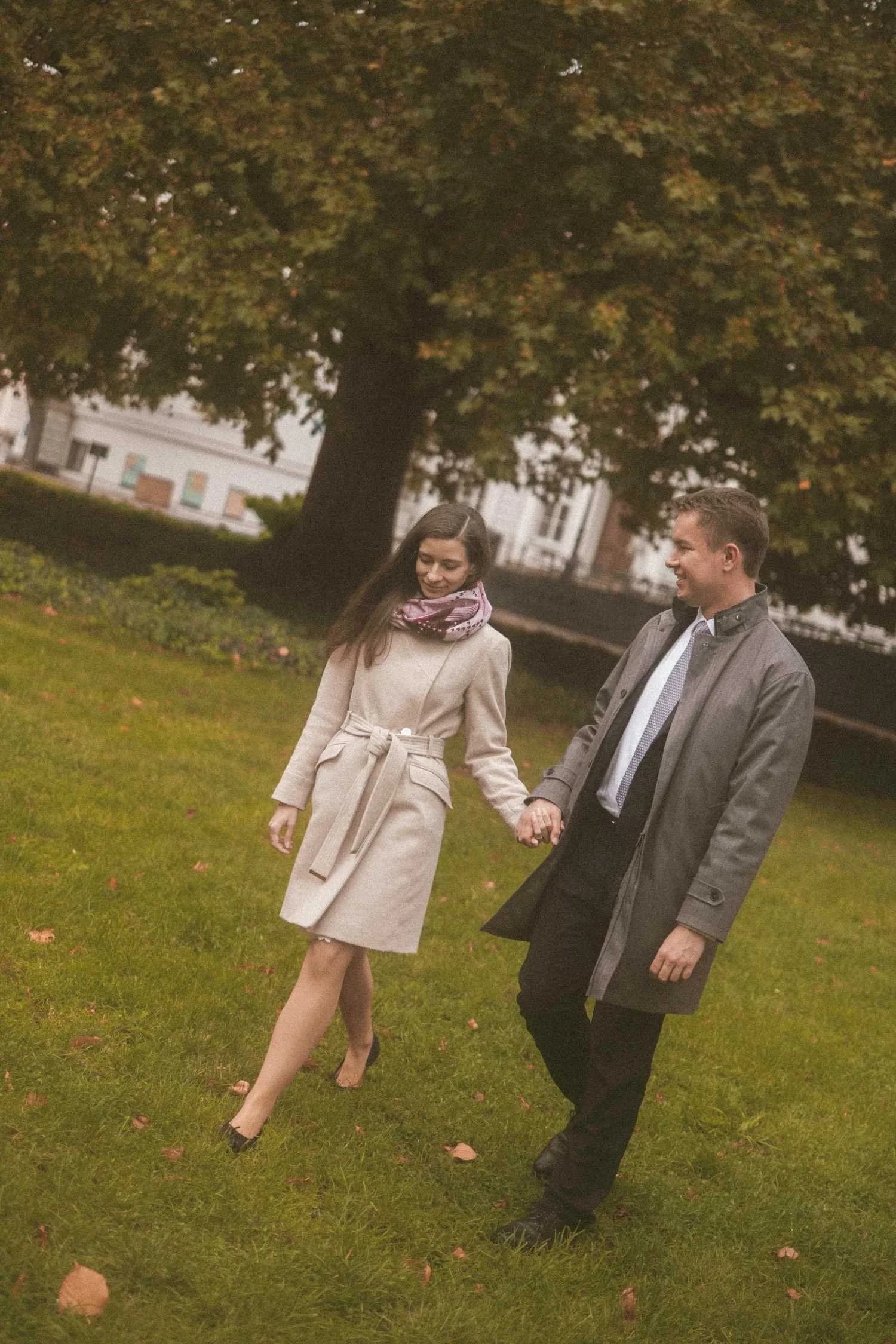Couple holding hands and walking through park in Berlin during romantic outdoor photoshoot