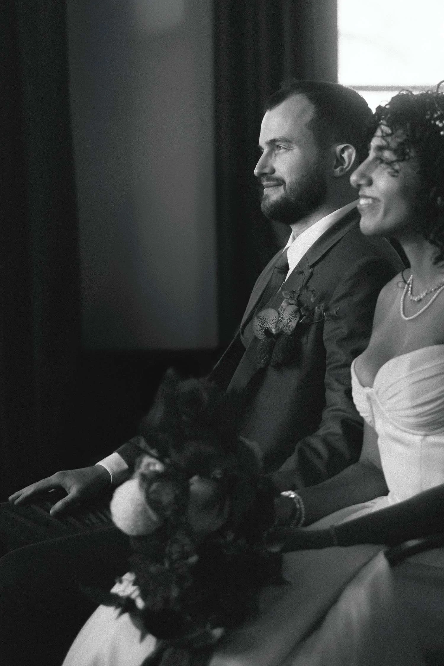 Bride and groom seated together during a quiet moment at a Standesamt civil wedding ceremony in Berlin, captured in black and white