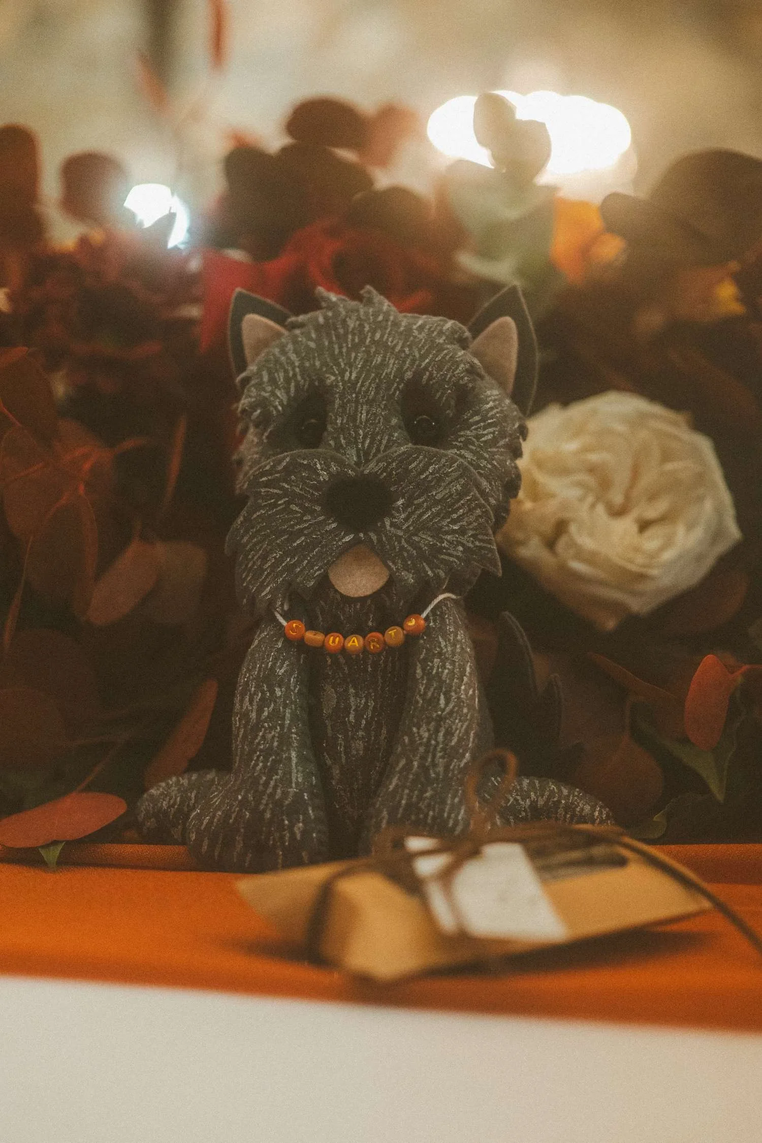 Dog figurine placed among floral decorations as a personal detail on wedding reception table