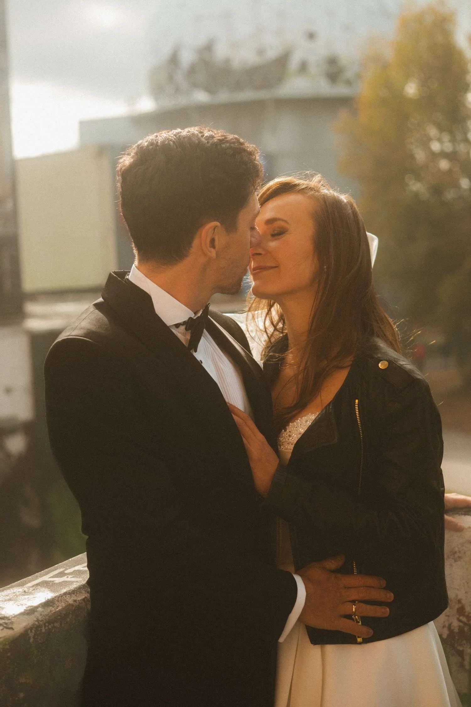 Bride and groom embracing with Teufelsberg radar dome in background during golden hour wedding photoshoot in Berlin