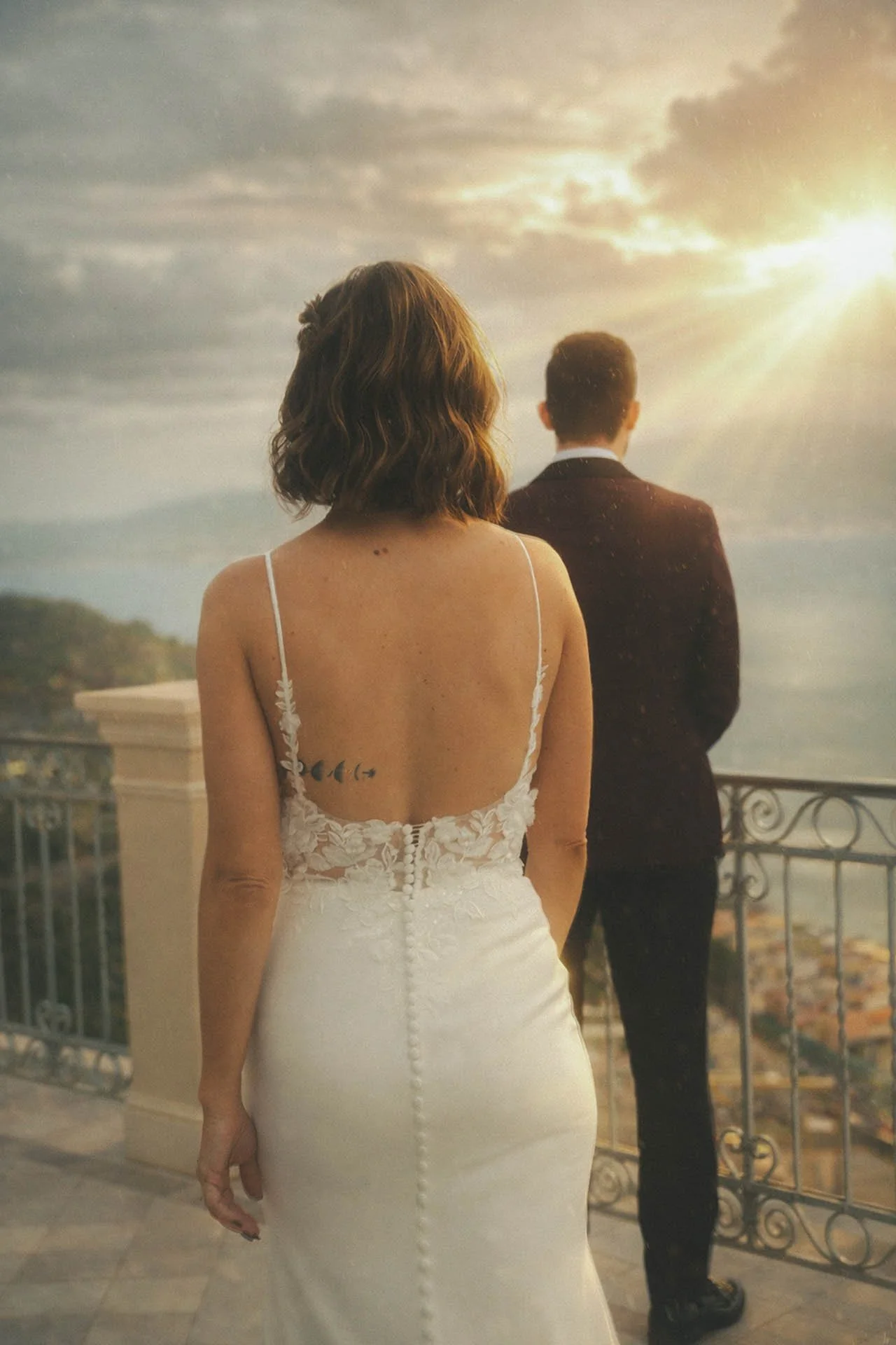 Bride walking toward groom during a sunset first look on a balcony overlooking the Sicilian coastline at an intimate destination wedding.