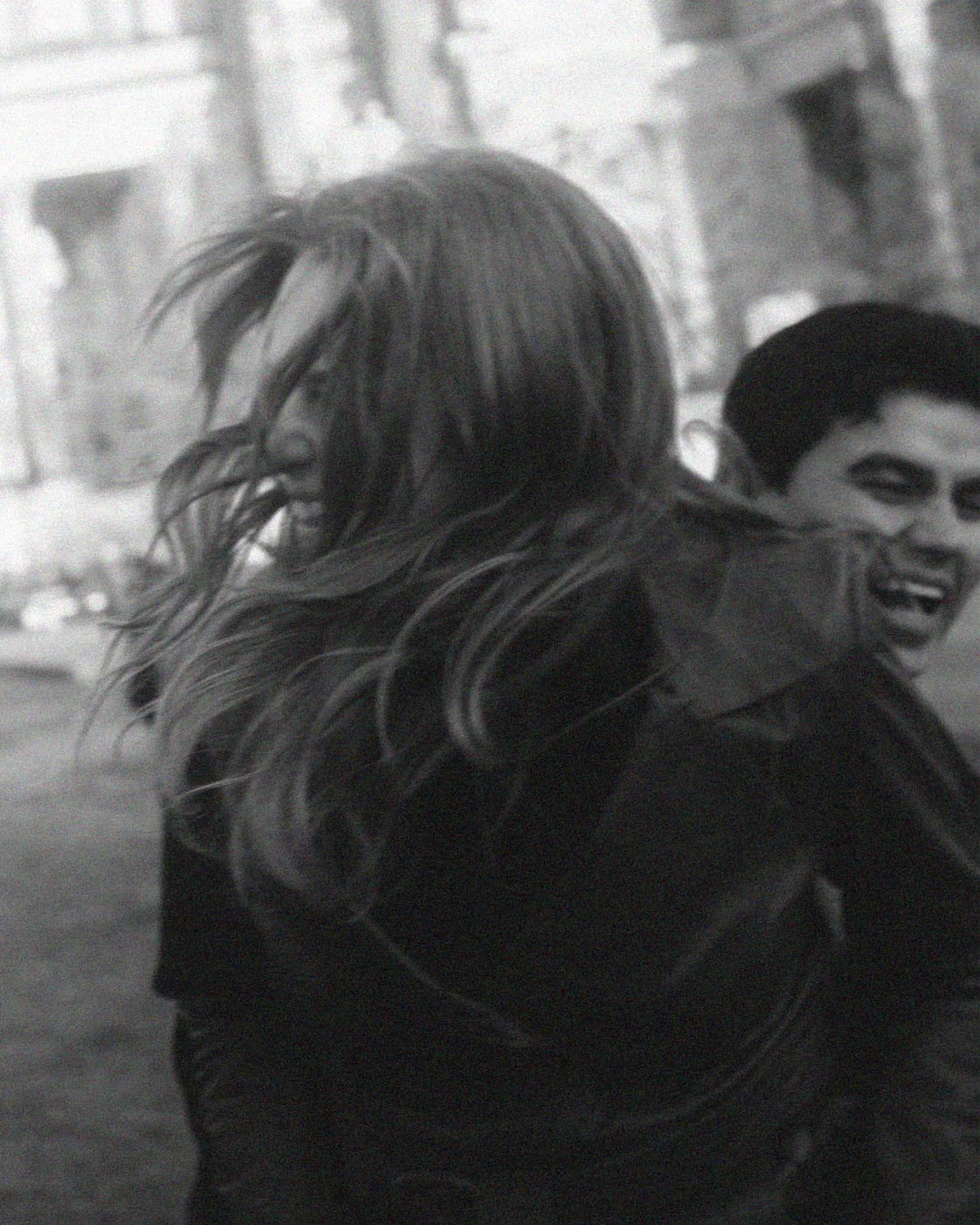 Intimate black and white couple portrait at night on Museum Island in Berlin, capturing a fun timeless moment.