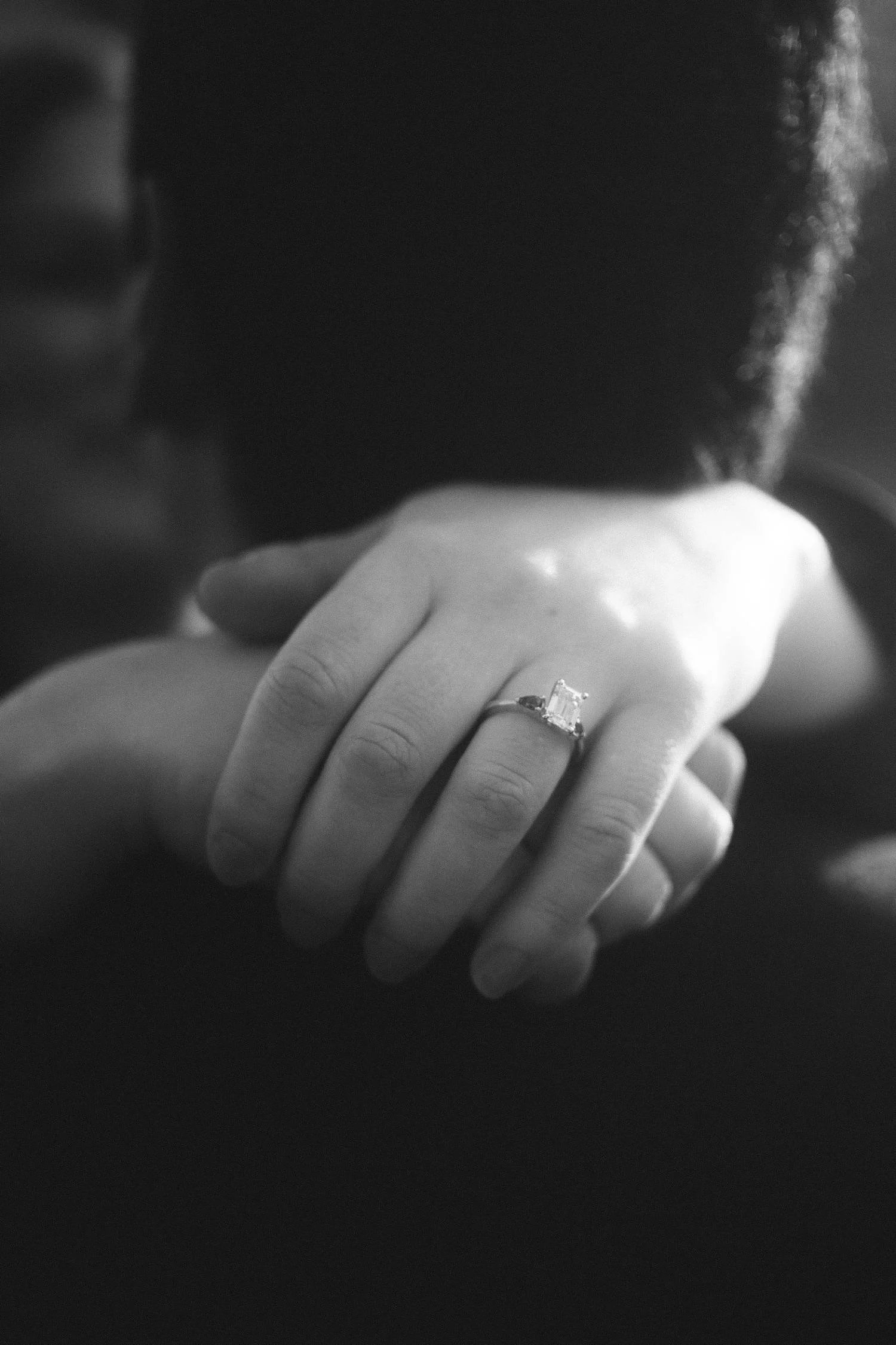Close-up black and white photo of an engagement ring on a woman’s hand during a couple’s proposal in Berlin
