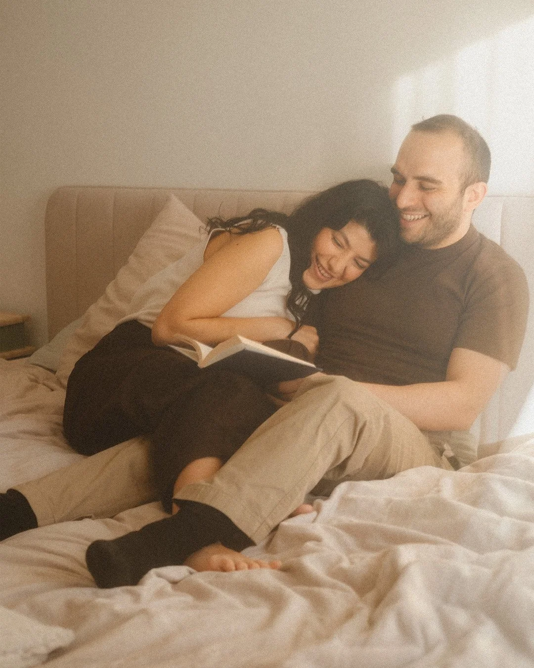Close-up candid portrait of a couple smiling together during a warm-toned lifestyle session in a Berlin Kreuzberg apartment.