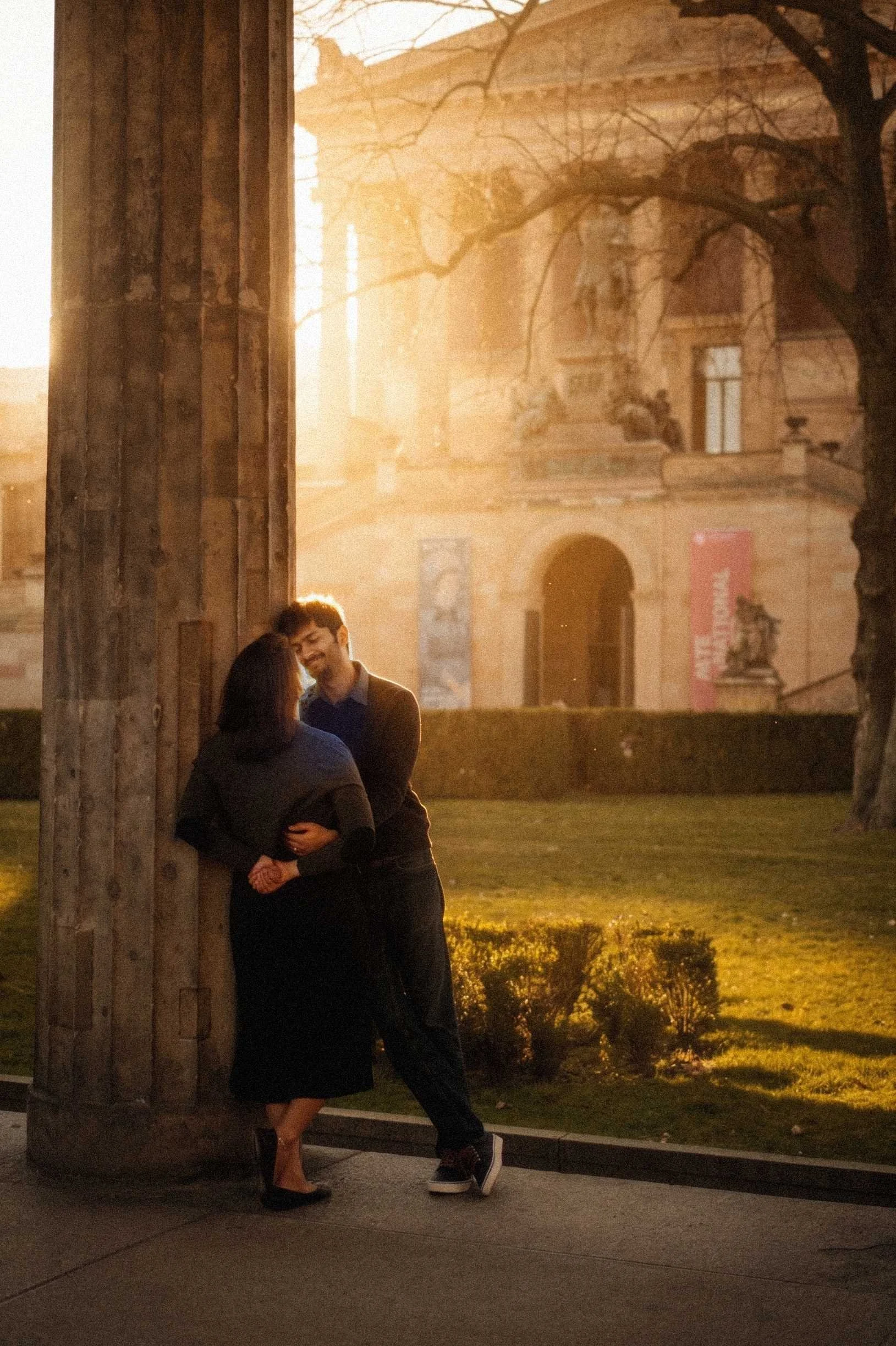 A candid, side-profile shot of a couple walking together during golden hour in a park.