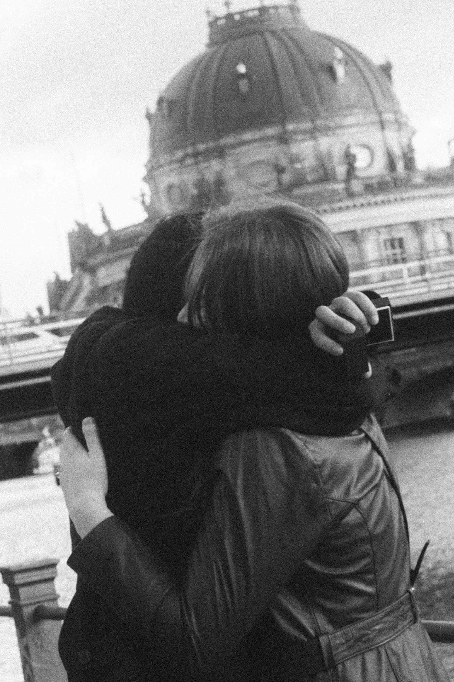 Couple embracing after a surprise proposal in front of the Bode Museum on Museum Island in Berlin, black and white moment