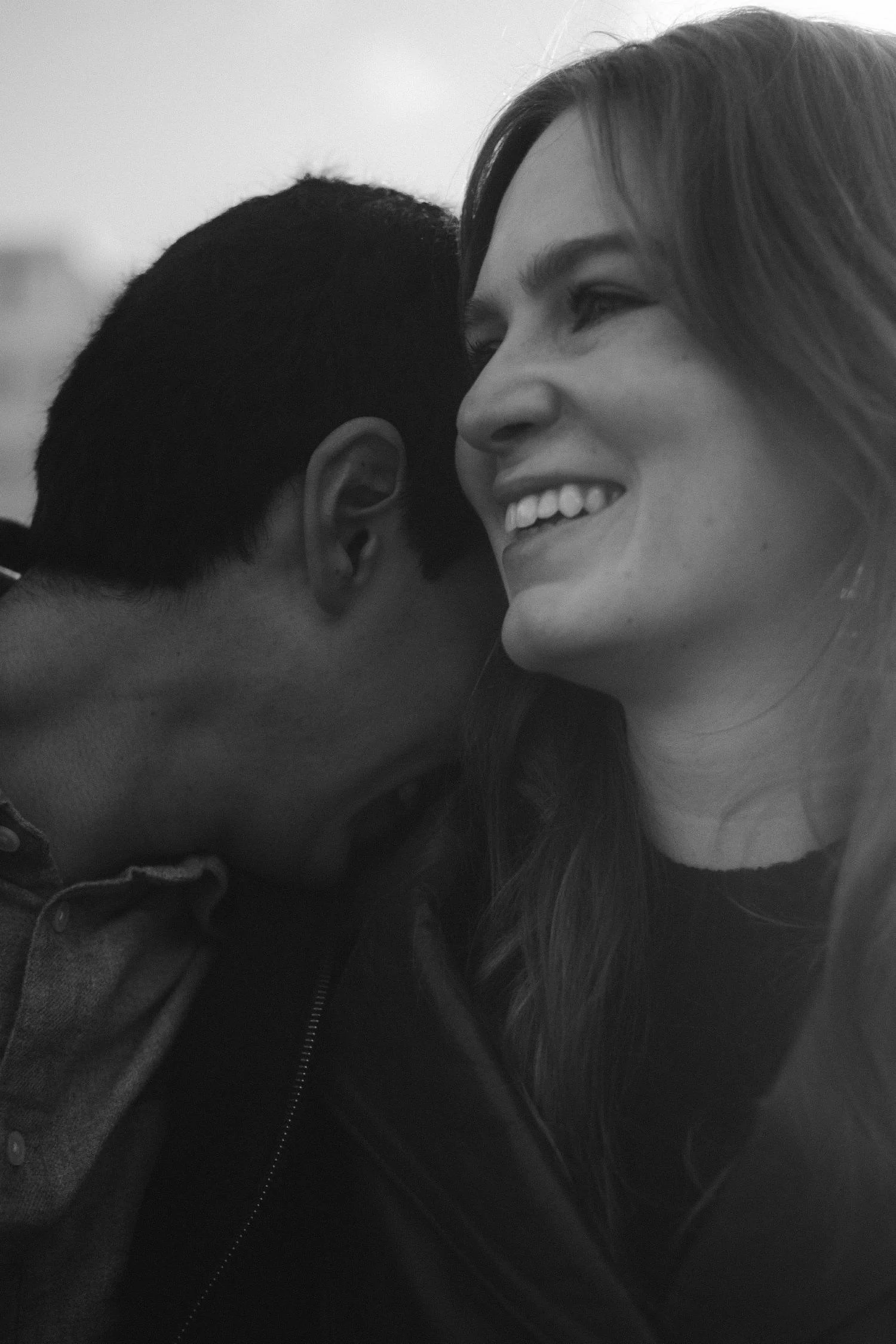 Black and white candid couple portrait in Berlin capturing an intimate, joyful moment during a romantic photoshoot.