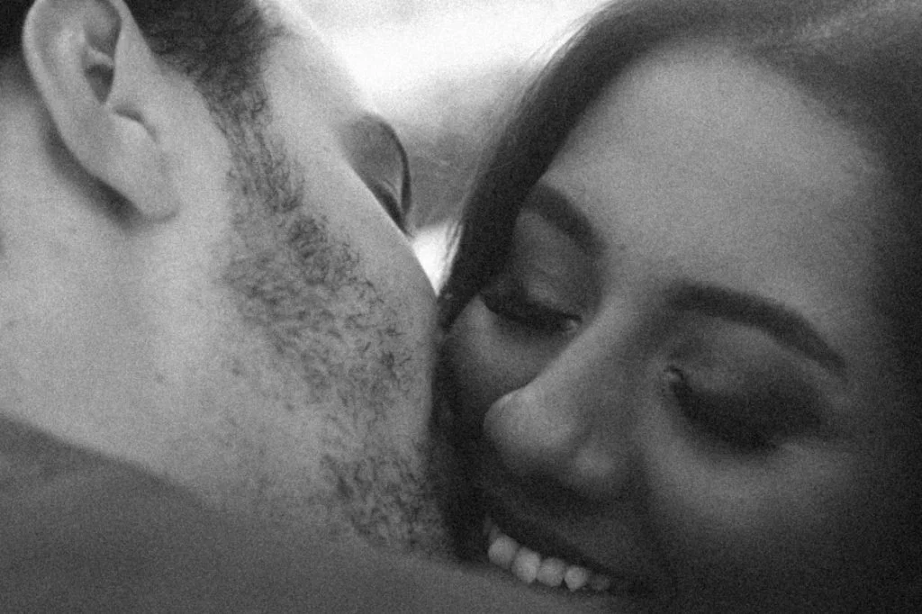 An intimate black and white close-up portrait of a couple sharing a tender embrace during an engagement photoshoot in Berlin.