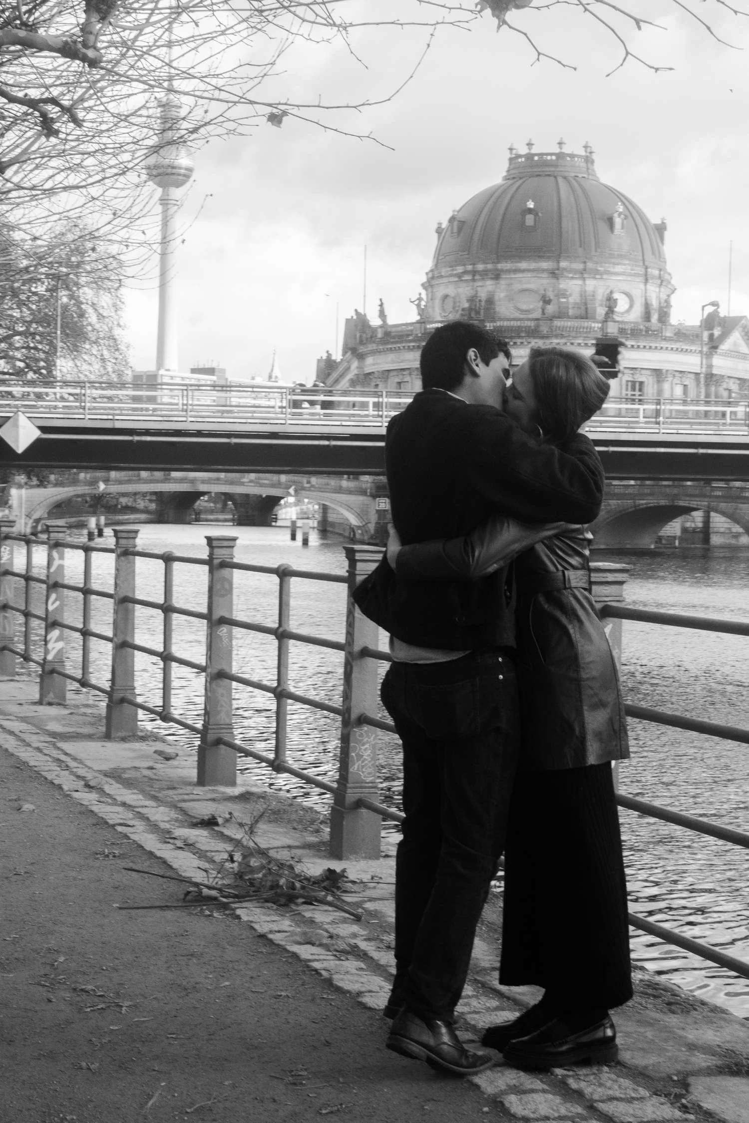 Black and white photo of couple kissing in front of the Bode Museum dome during their Berlin engagement photo session