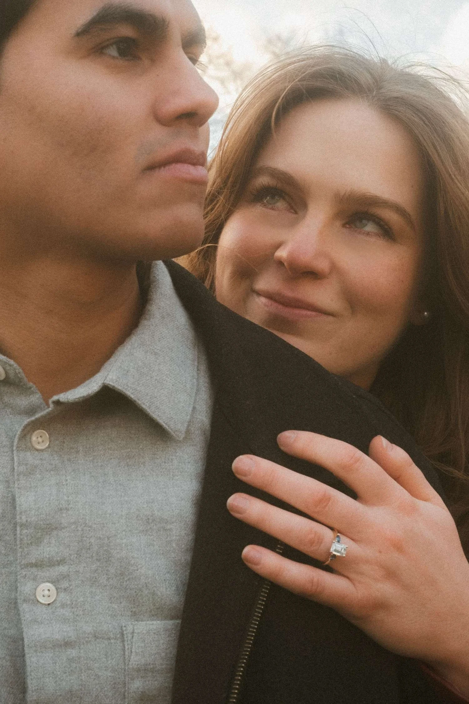 Candid engagement portrait of a couple in Berlin, close-up of an engagement ring during a romantic proposal moment.