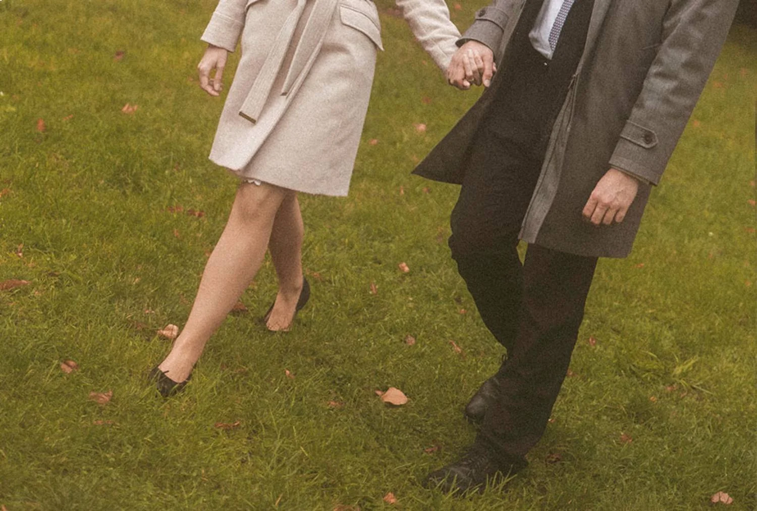 Close up detail of couple holding hands while walking through park in Berlin during romantic photoshoot