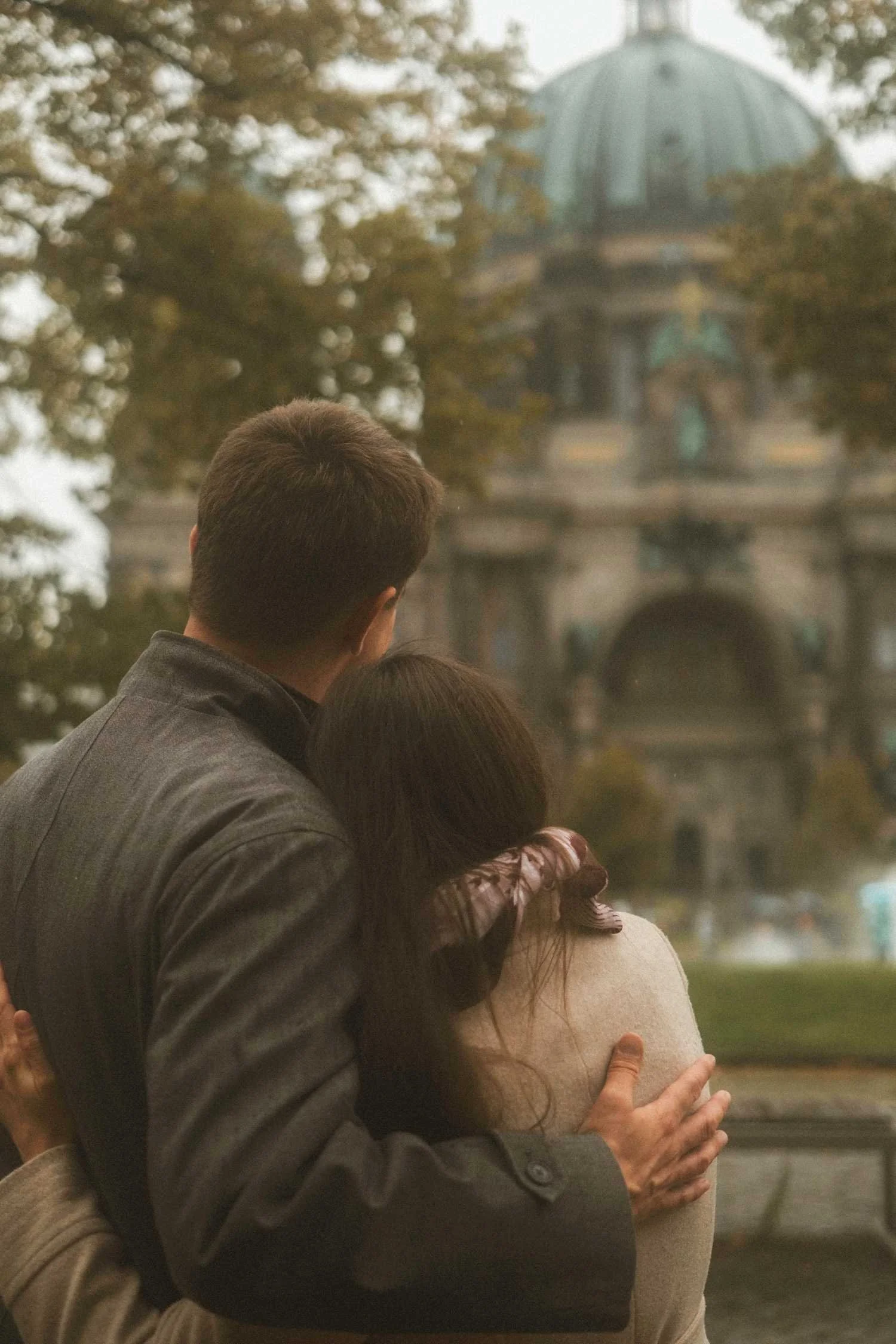Couple embracing from behind while looking at Berliner Dom during Berlin photoshoot