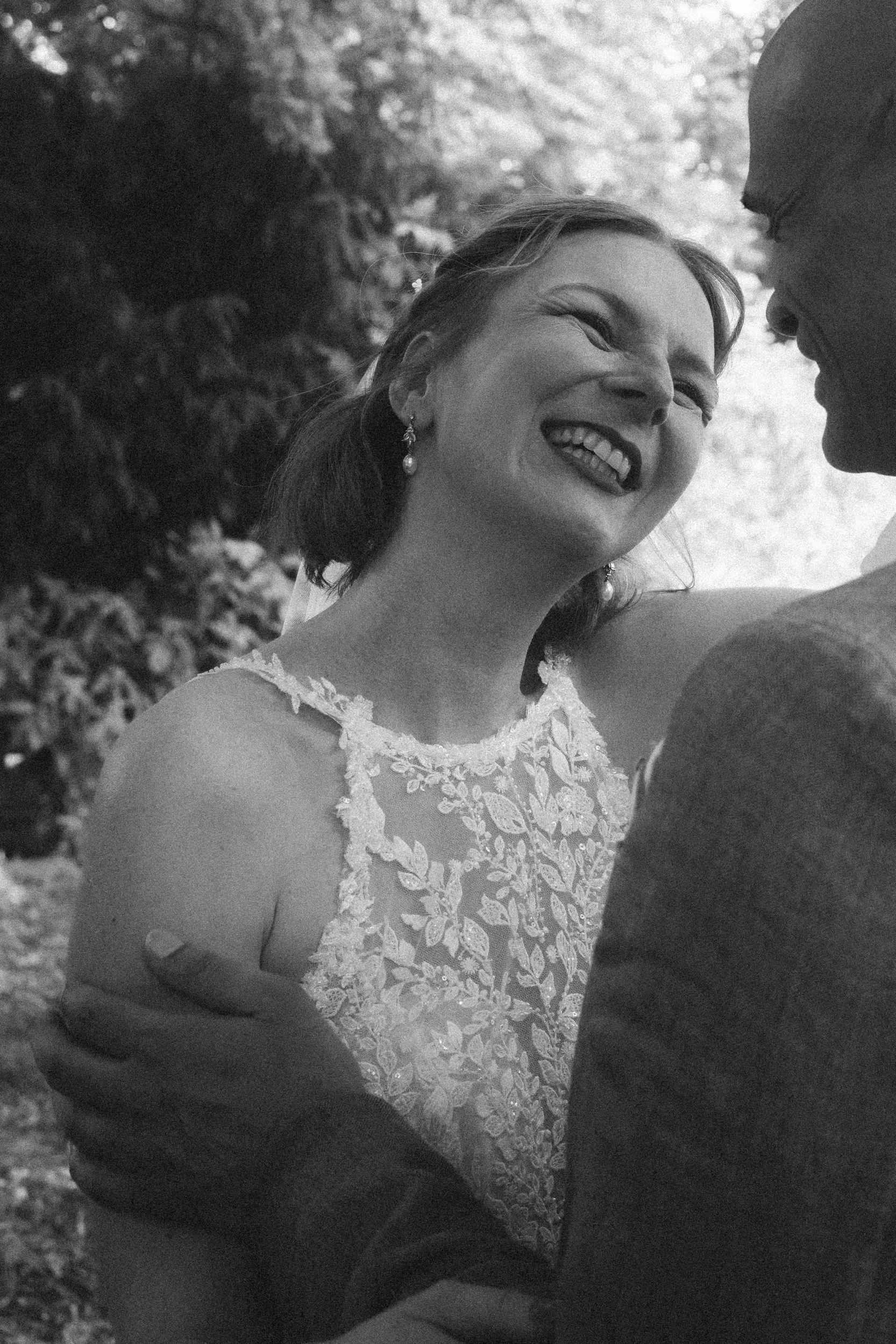 Joyful close black and white portrait of bride laughing outdoors during Berlin wedding portrait session