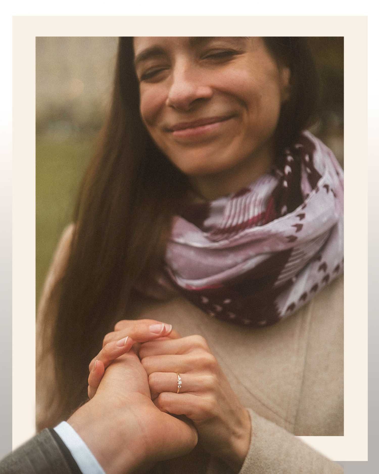 Close up of woman holding partner’s hand showing engagement ring during romantic outdoor photoshoot in Berlin