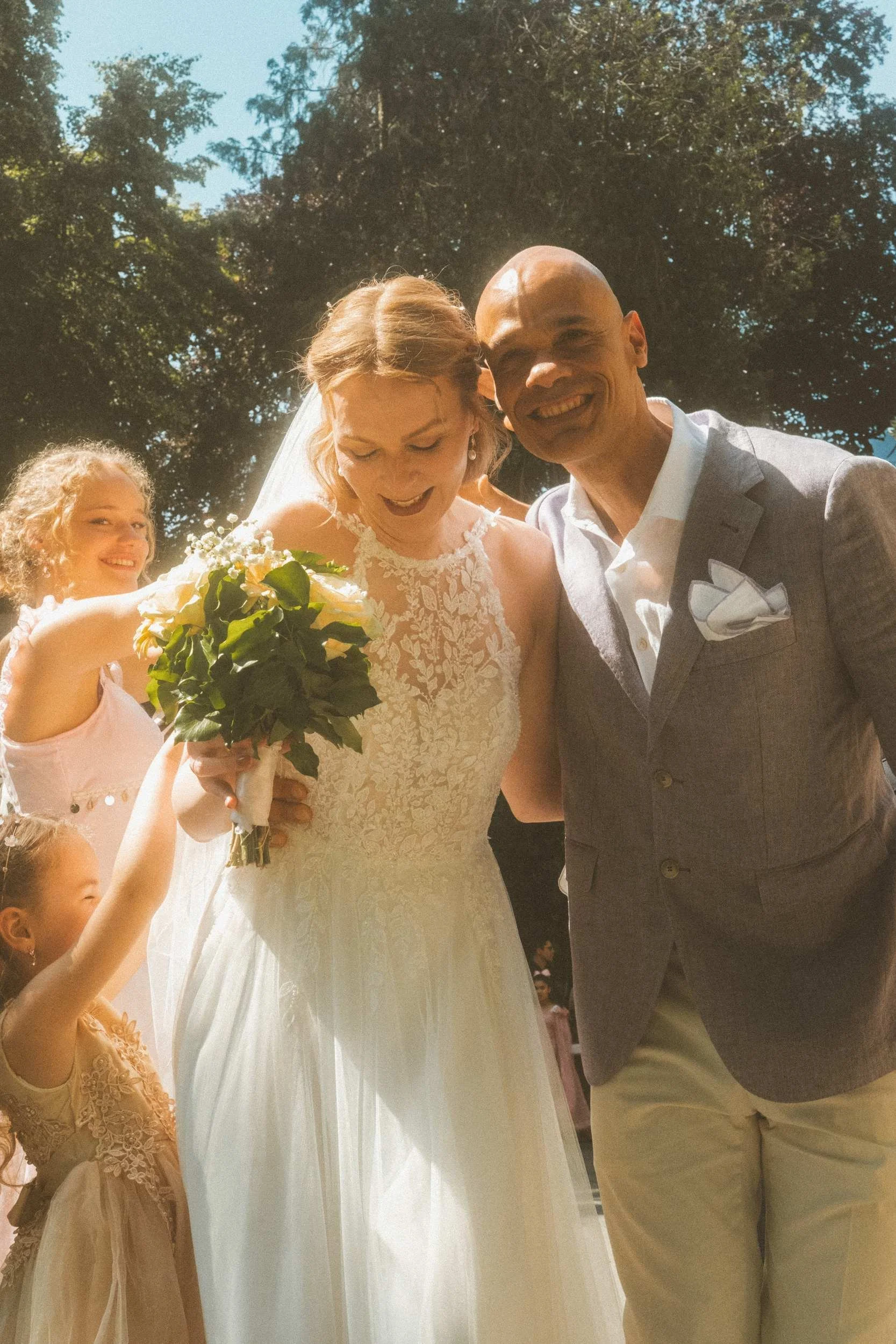 Couple laughing with guests and flower girl outside the Standesamt registry office in Berlin