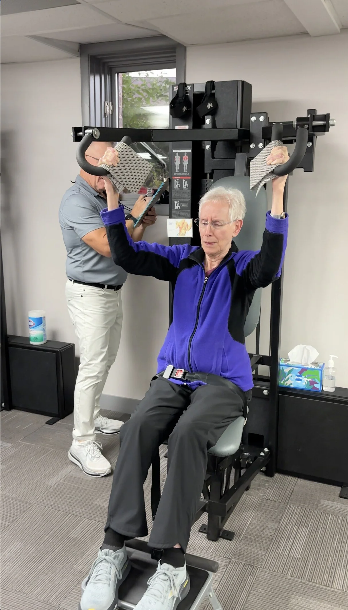 Client doing an overhead press with a trainer at Strength Evolution Madison