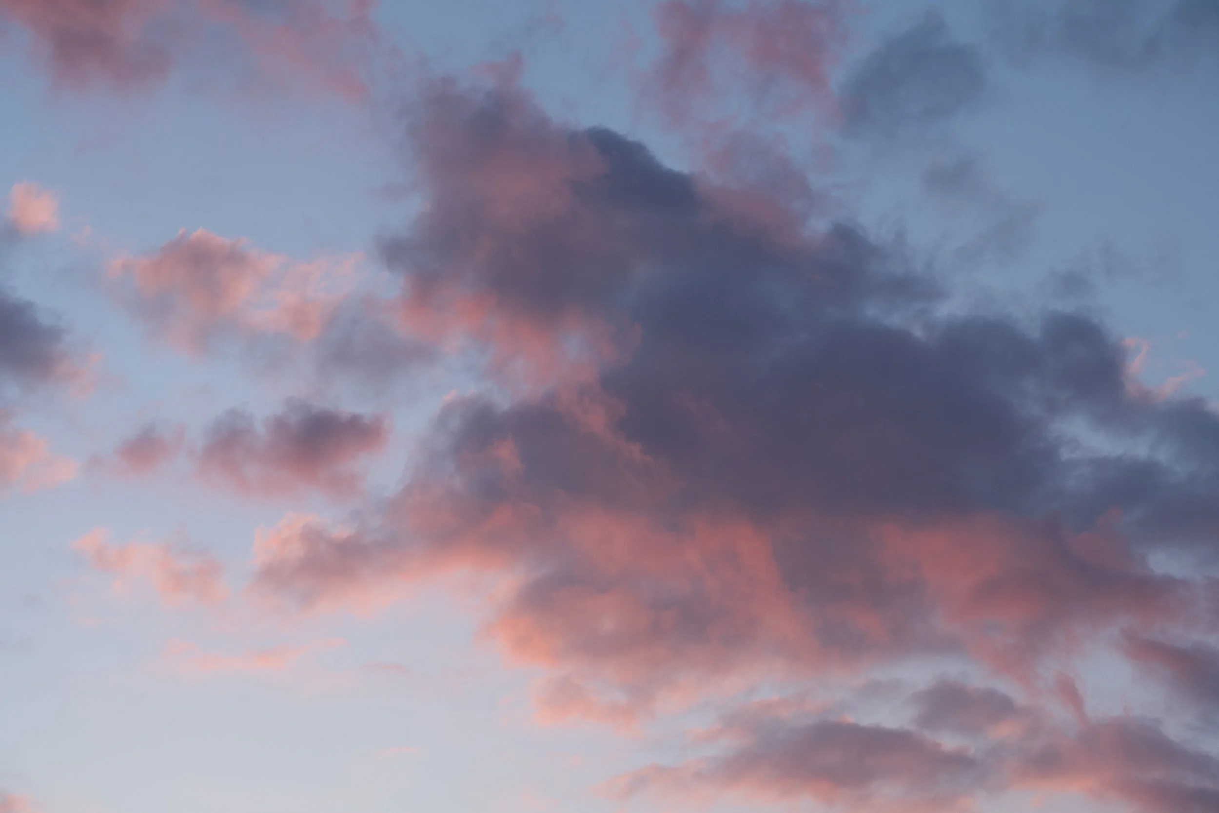 Colorful clouds in a purple and pink sky at sunset or sunrise.