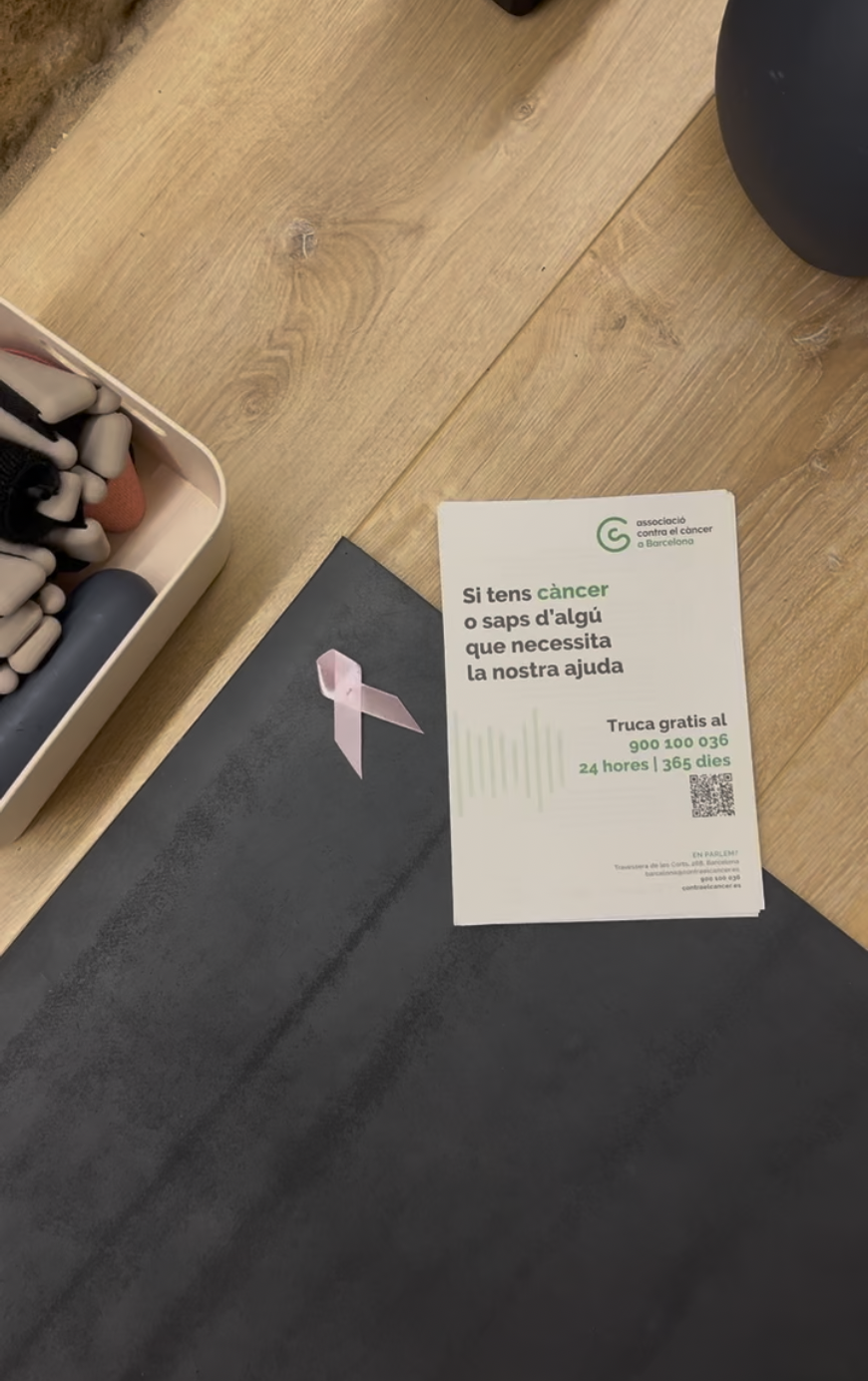 Lazo rosa e información de la AECC en la clase benéfica Barre Pink de Société Barre, Terrassa