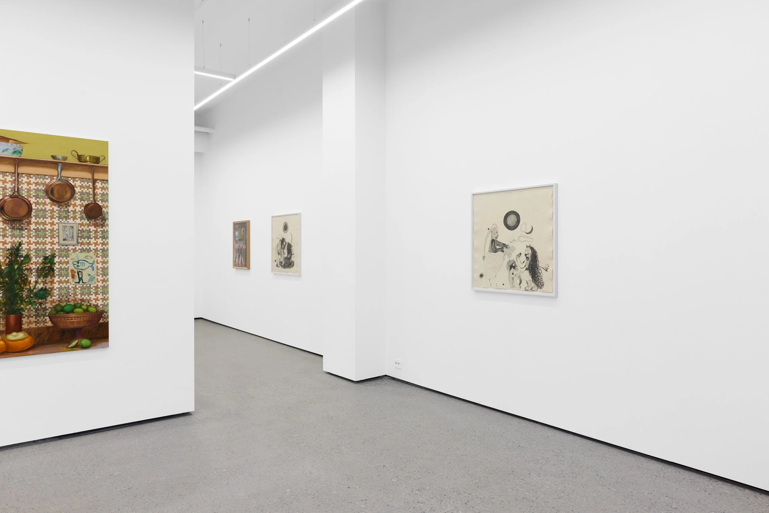 Art gallery interior with white walls displaying framed artworks, featuring a corner with an eclectic display of hanging copper pots, a patterned tapestry with colorful illustrations, and a potted plant