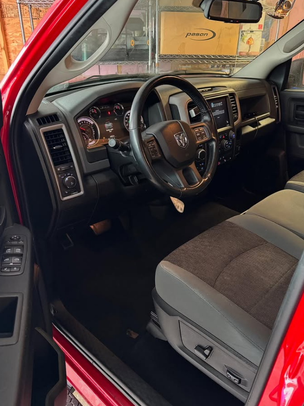 Interior view of a Dodge vehicle, showing the steering wheel, dashboard, and front seats.