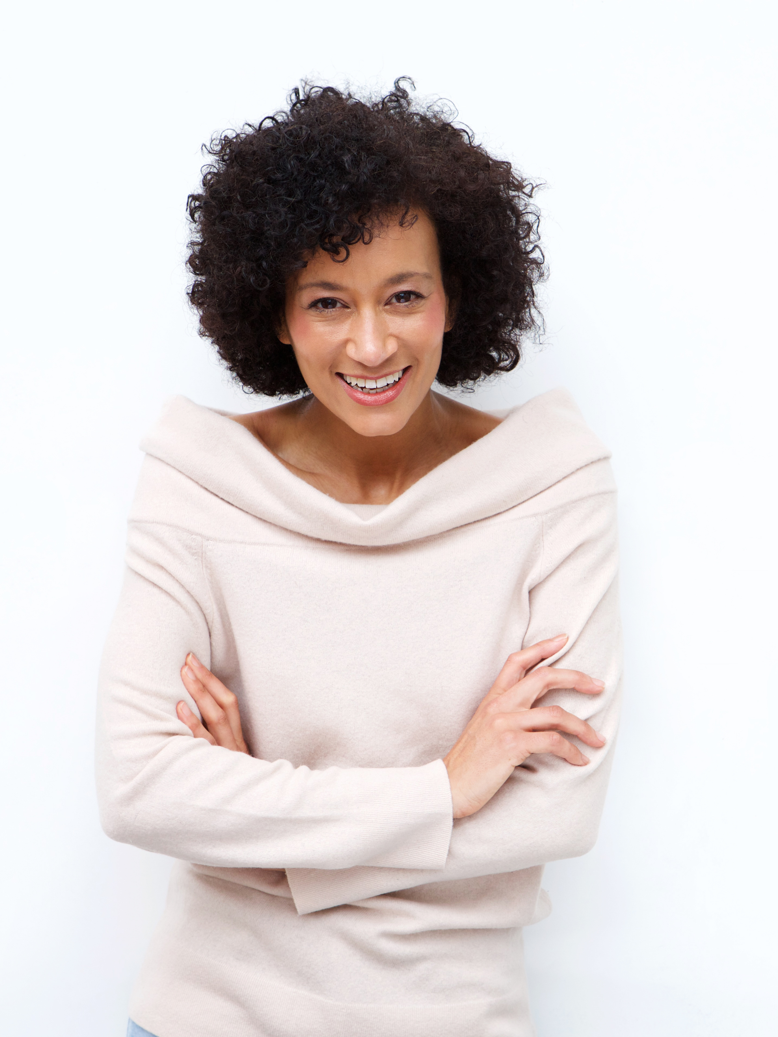 curly haired black woman in her 50s smiling wearing a white shirt