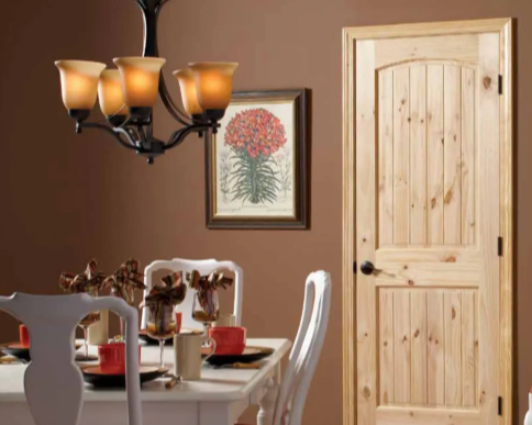 Dining room with a table and chairs, a chandelier, a framed botanical print, and a wooden door.