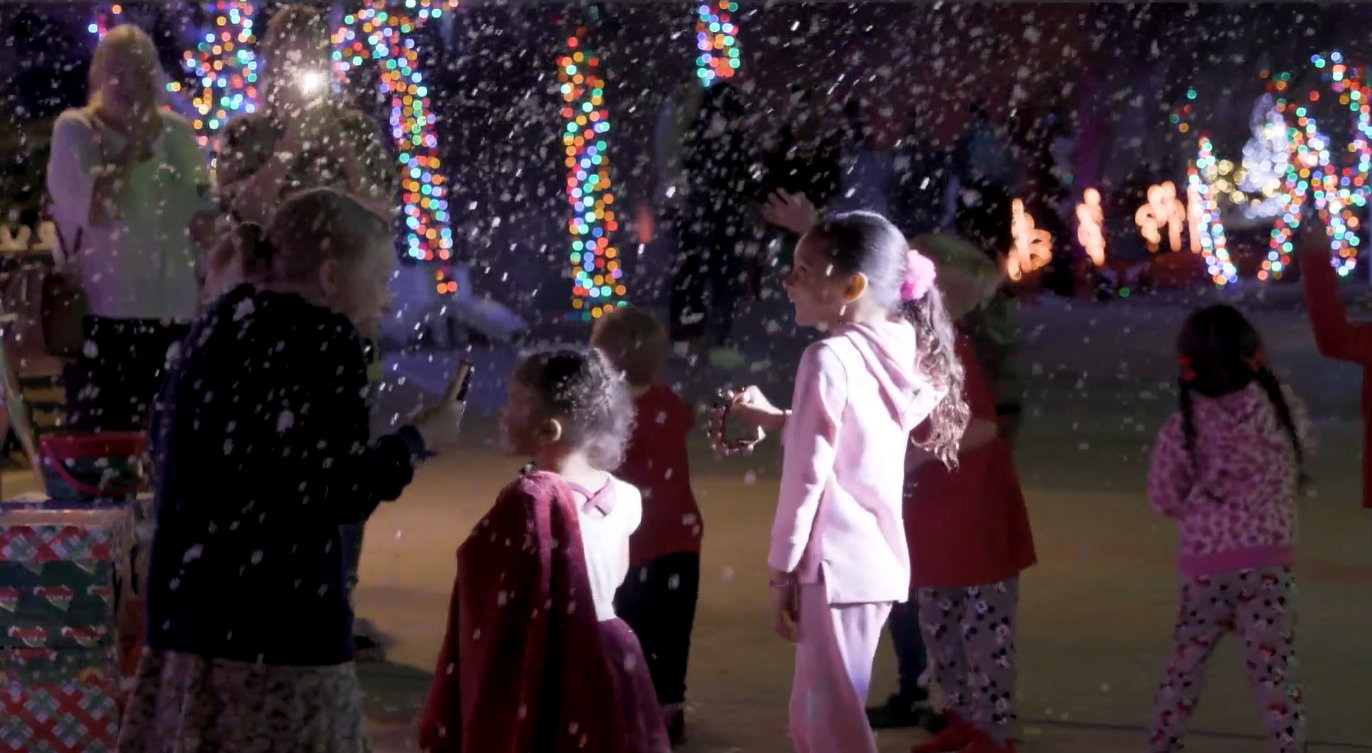 Children celebrating Christmas at night with Christmas lights and snow, engaging in fun activities. Tampa Bay Holiday Show Clearwater Florida