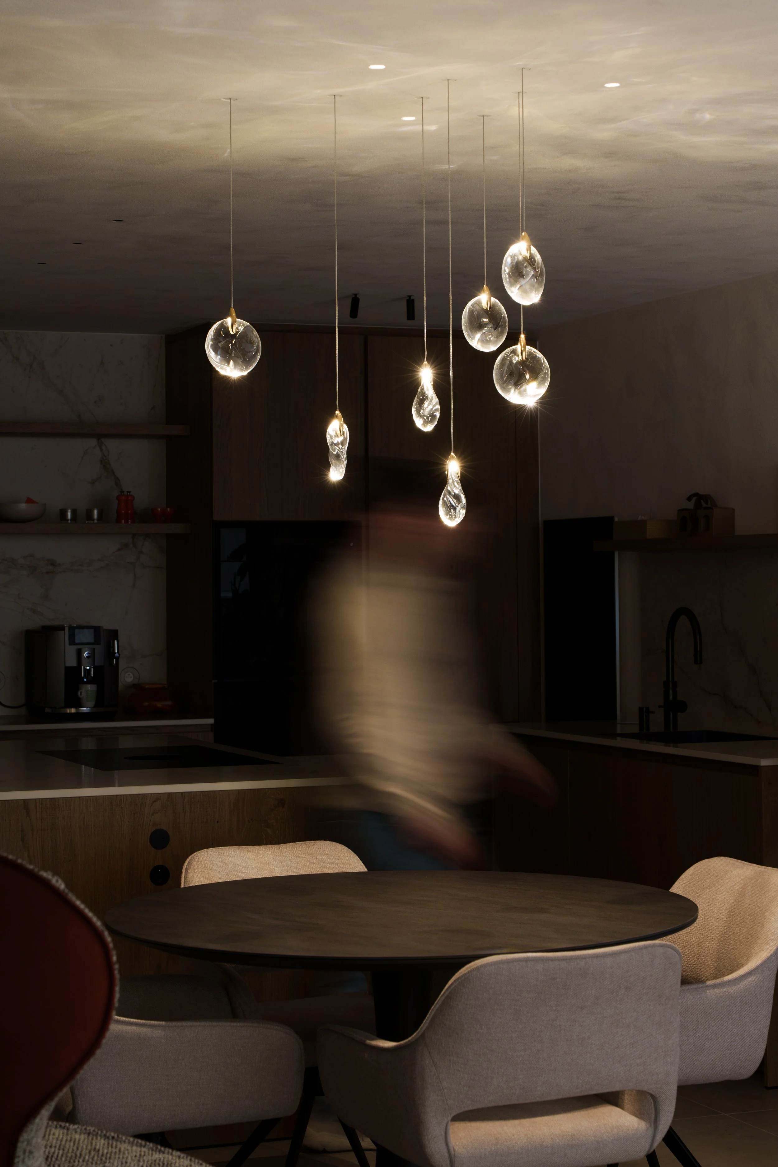 Elegant crystal composition chandelier above a dining table, creating a luxurious ambiance and enhancing modern interior design