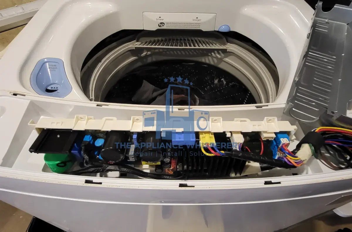 Top view of an open washing machine with exposed wiring and internal components.