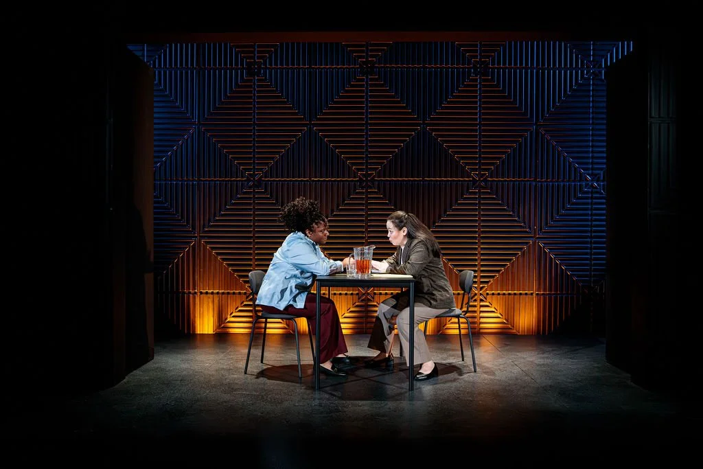 two women sit at a table, futuristic background