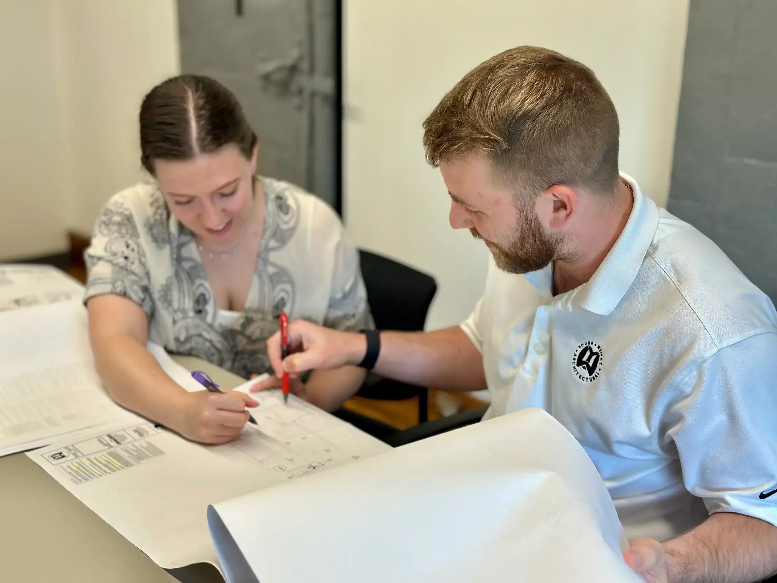 Two architects reviewing drawings and making notes