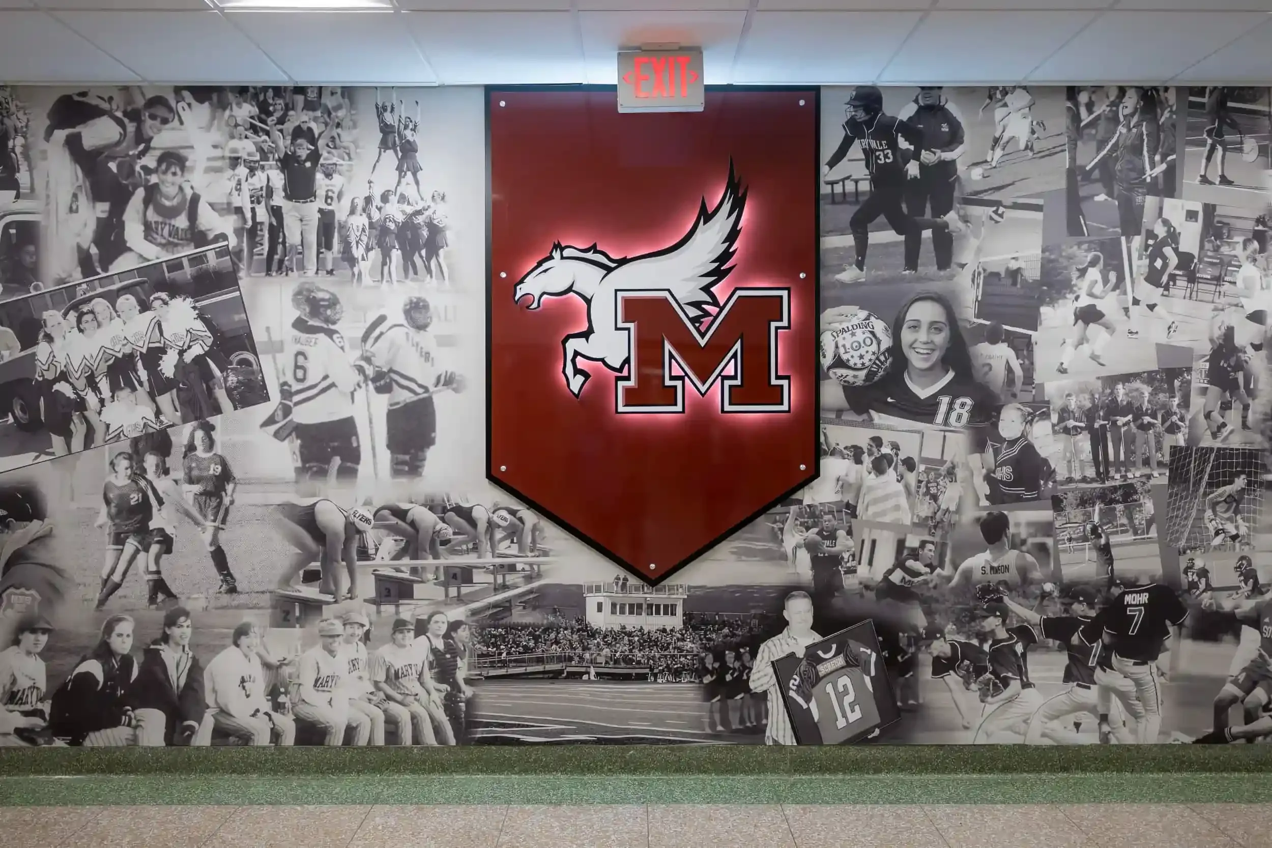 A logo and photo wall in the new gymnasium lobby
