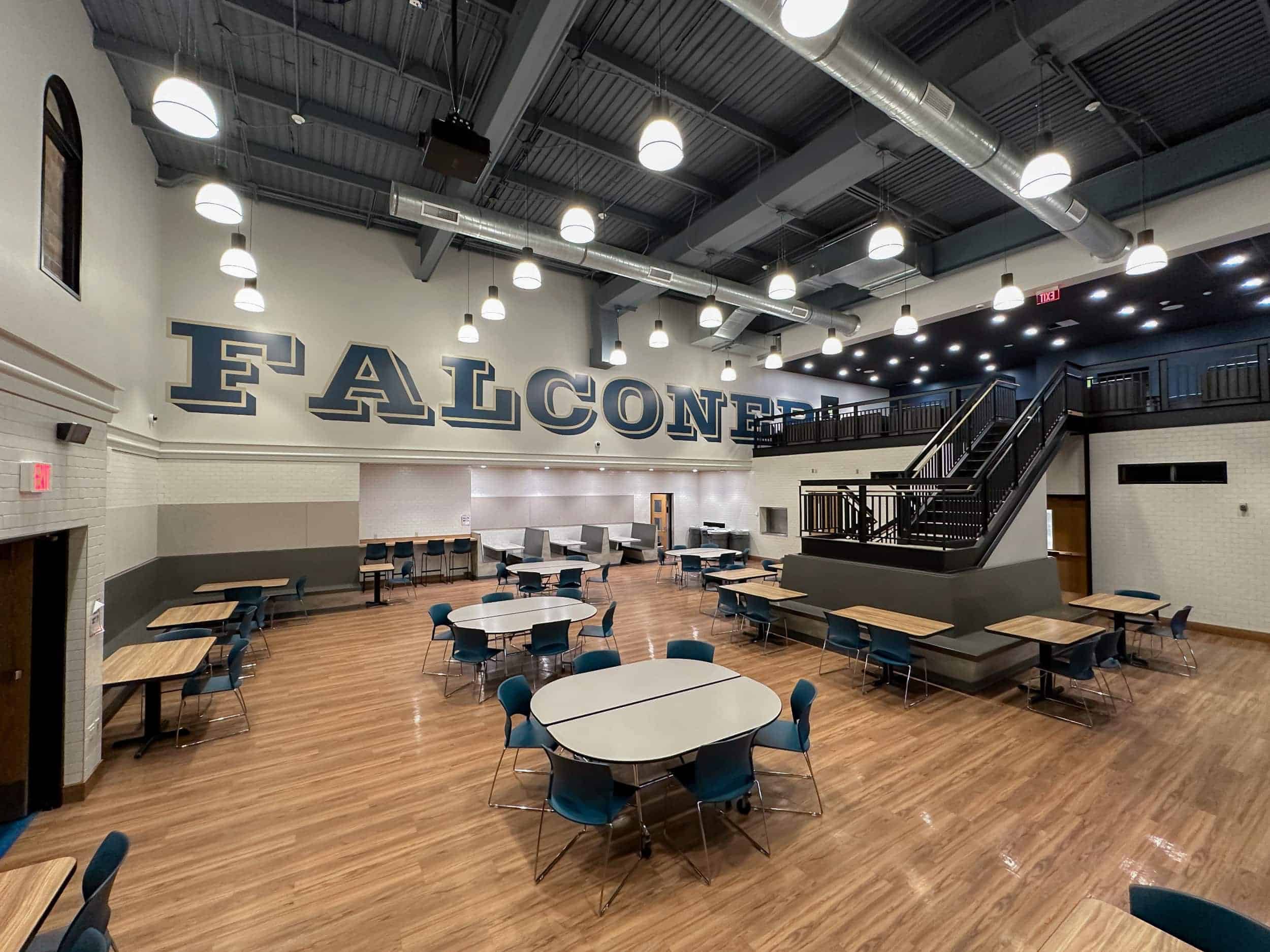 The Falconer cafeteria and socializing space with the school's name in large block letters on one wall