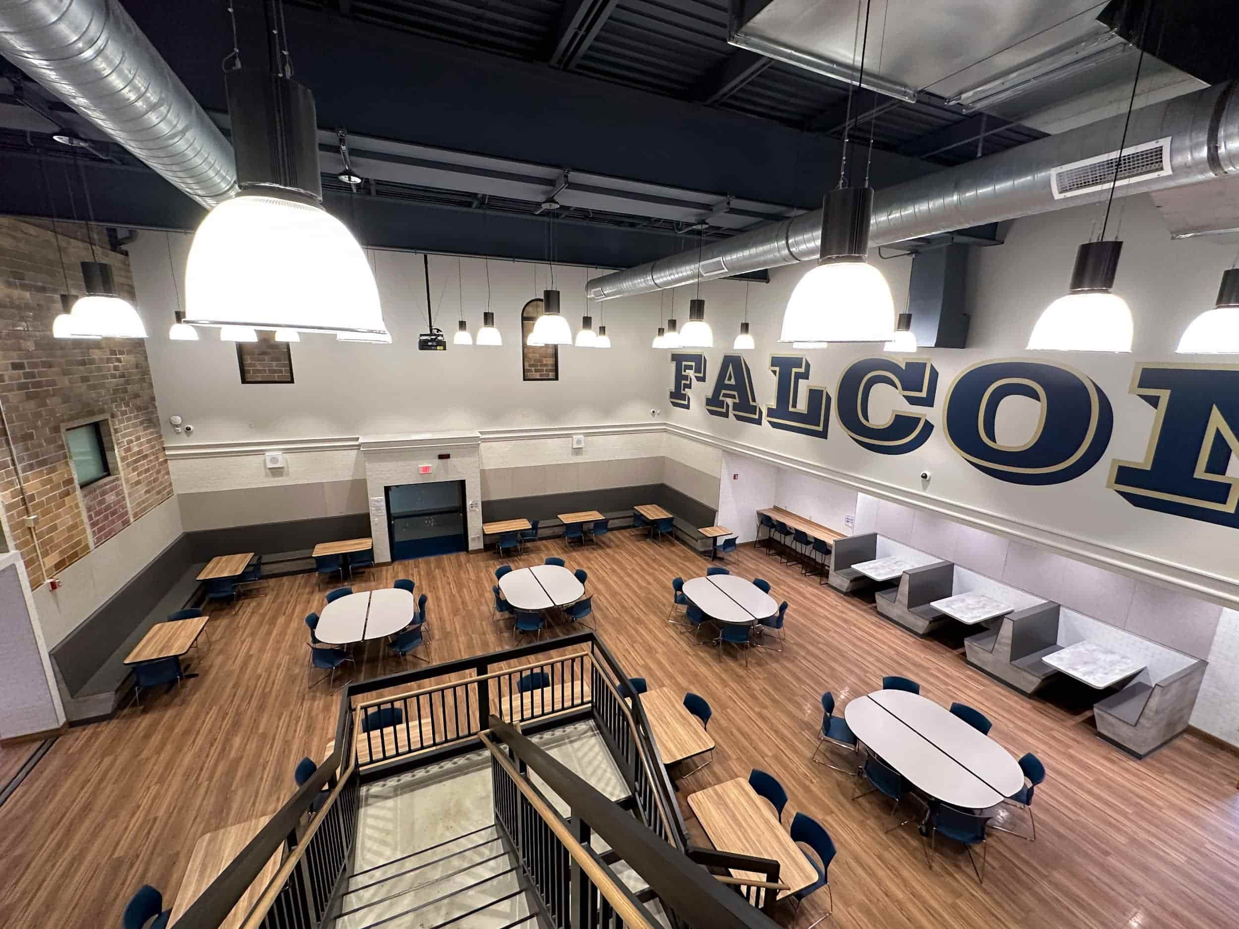 The Falconer cafeteria and socializing space with the school's name in large block letters on one wall