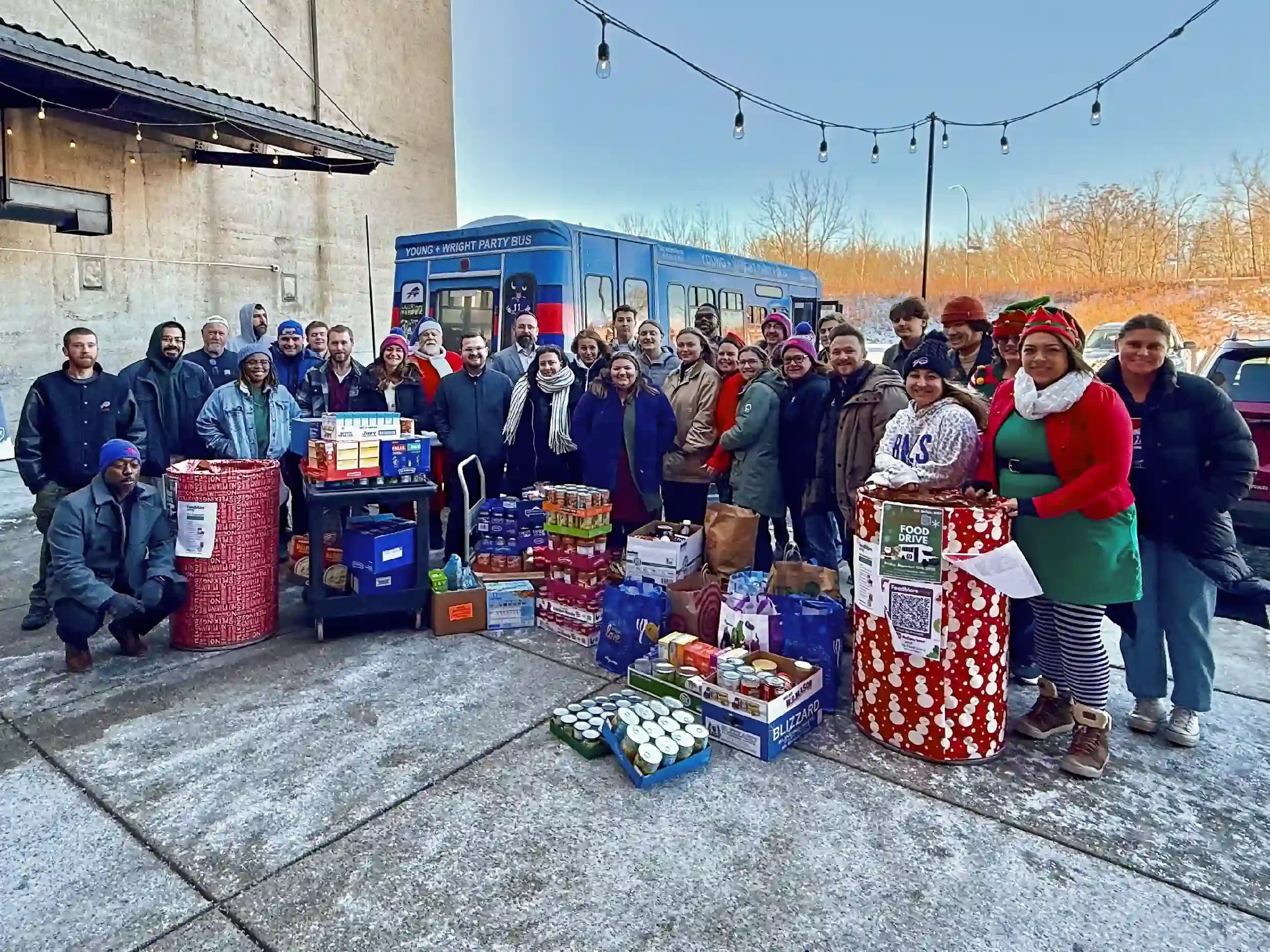Jerry Young, one of the partner architects, dressed as Santa with employees grouped around the firm's annual food drive donation