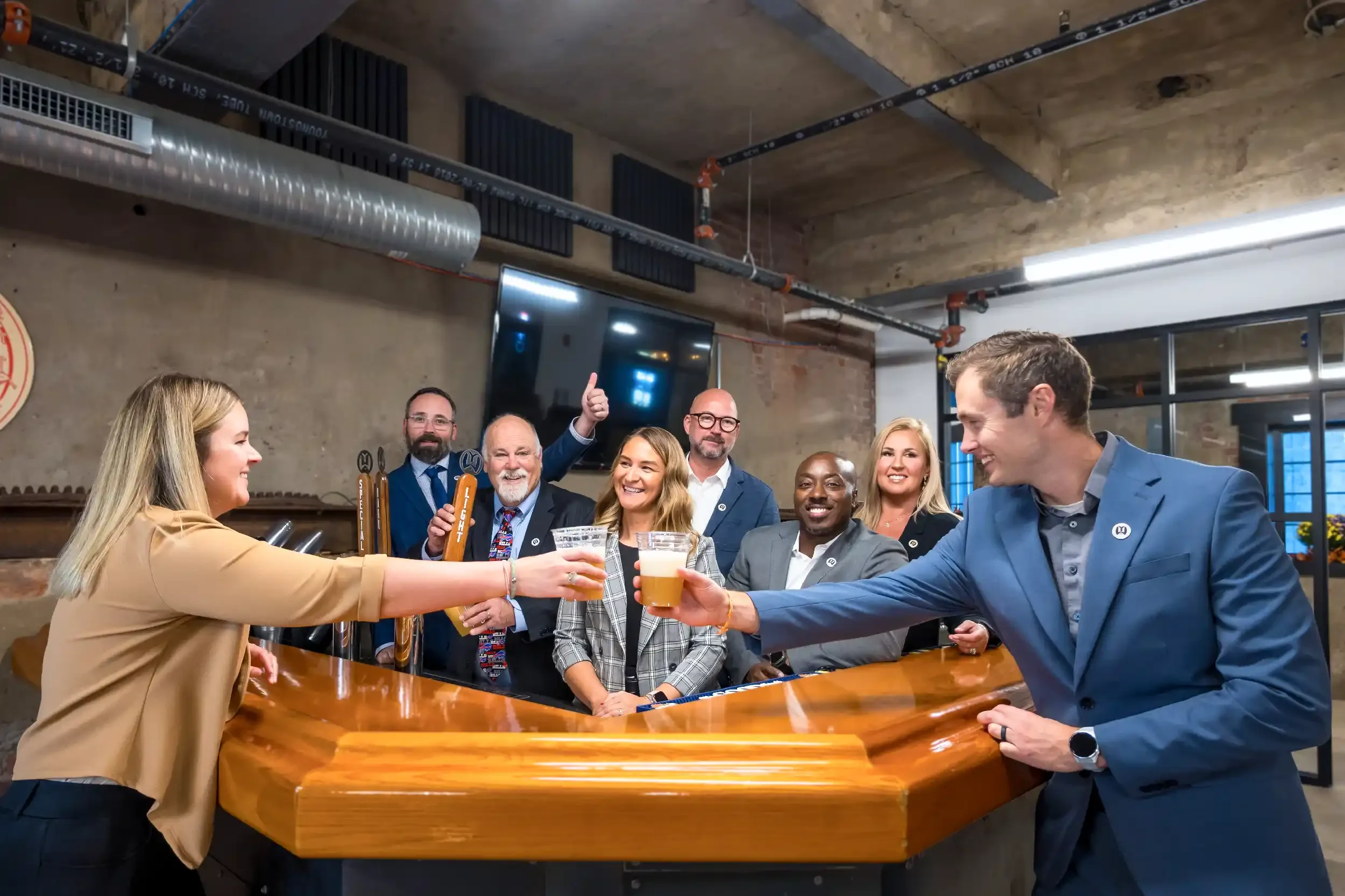 New partners Alyssa Catlin and Steve Shchurowsky toast each other while the Young + Wright partners and associates cheer
