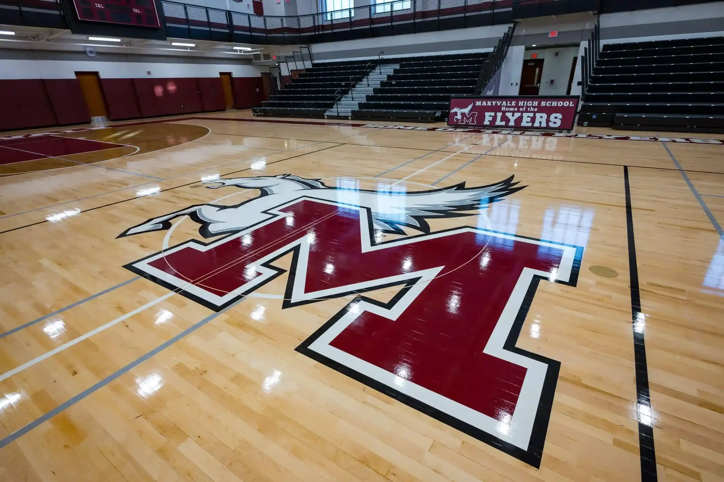 A view of the new gymnasium floor with the school's logo in the foreground