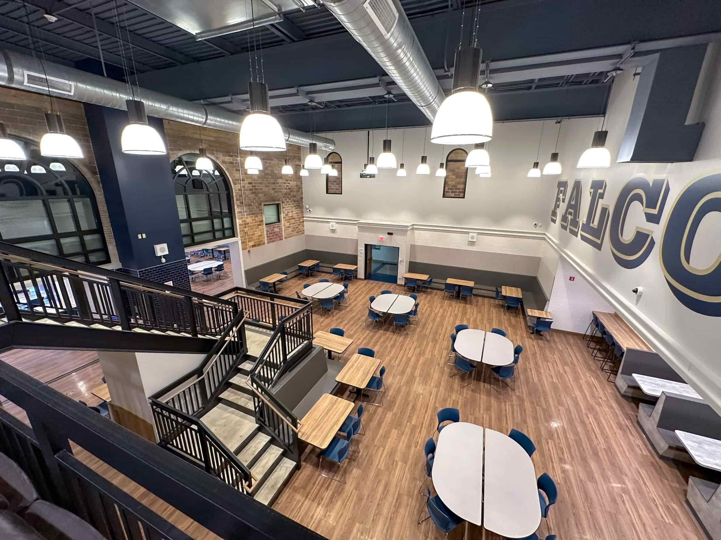 Looking down on the cafeteria's first floor, with the school's name visible on the right wall