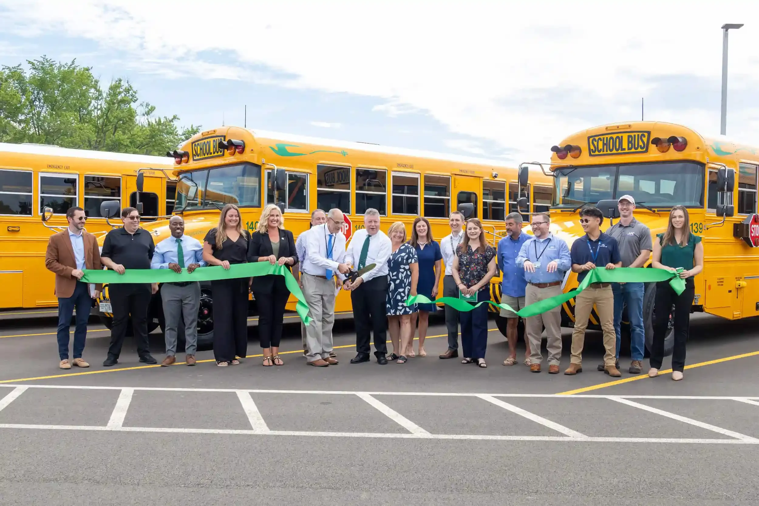 The ribbon cutting with a fleet of electric buses in the background
