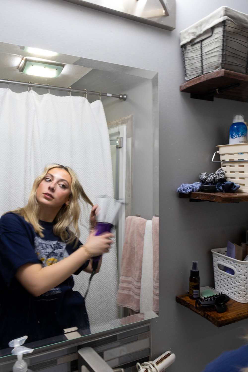 As she sections her hair between her fingers, Lindsay Best uses a hair waver to style for the evening. She is from a suburban area of Las Vegas in Nevada called Henderson. She attends college at the University of Nebraska— Lincoln, where she is in he