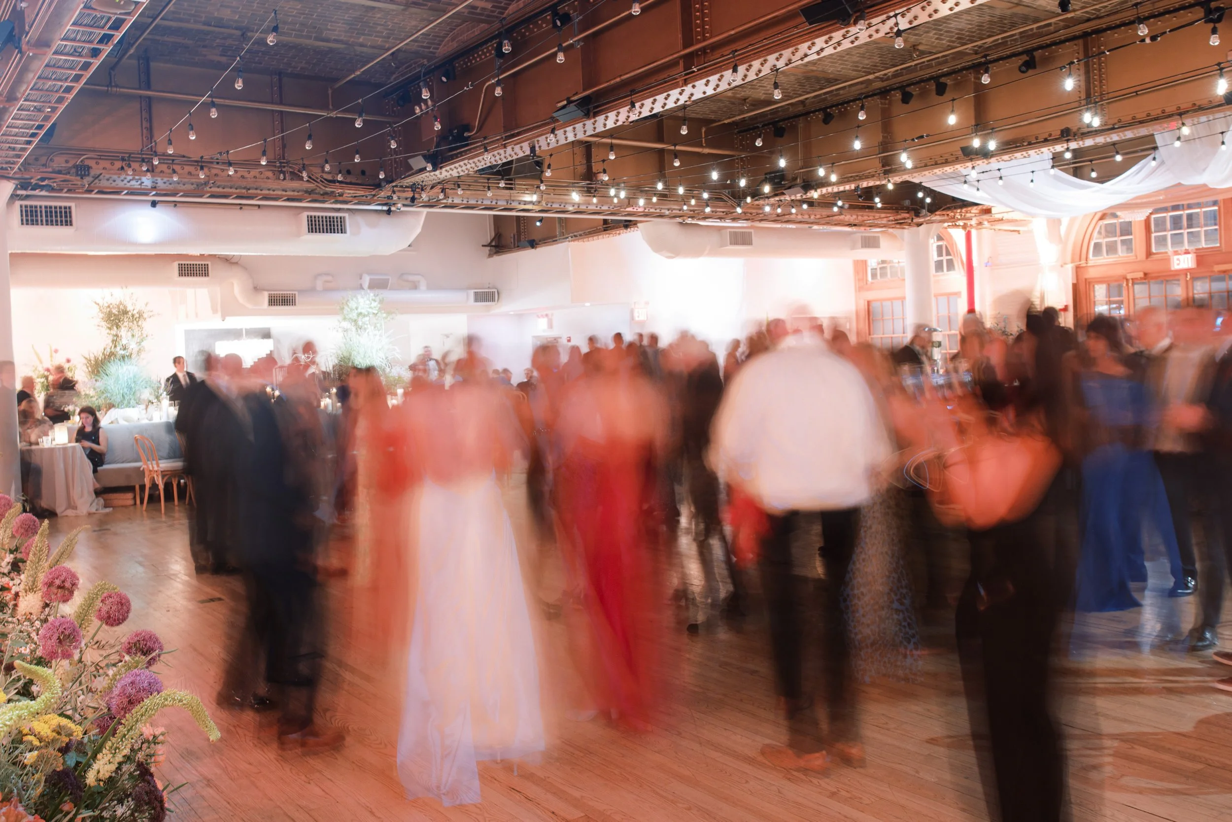 High-energy wedding dance floor under café lights at the Altman Building in Chelsea NYC.